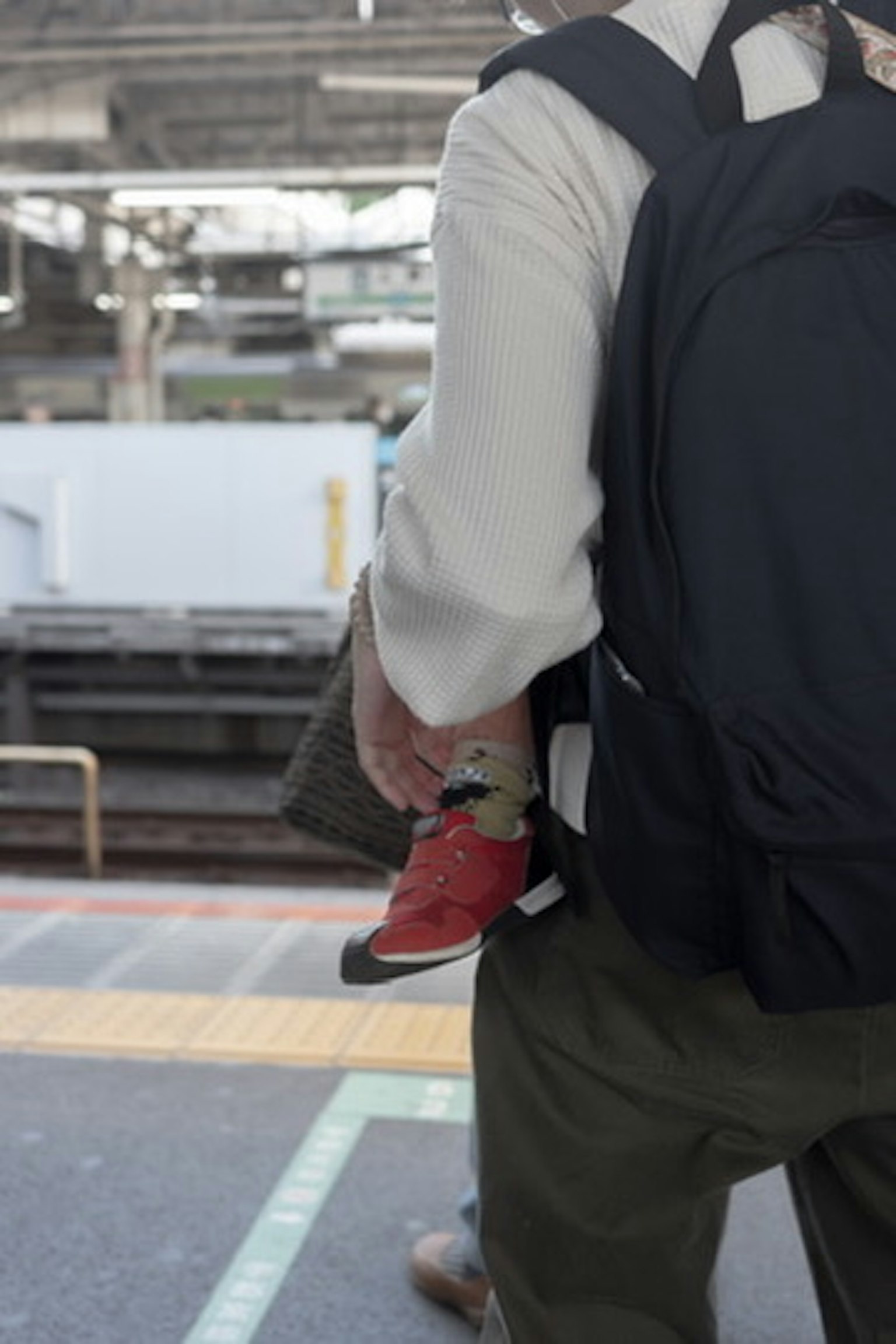 Adult holding a child at a train station platform