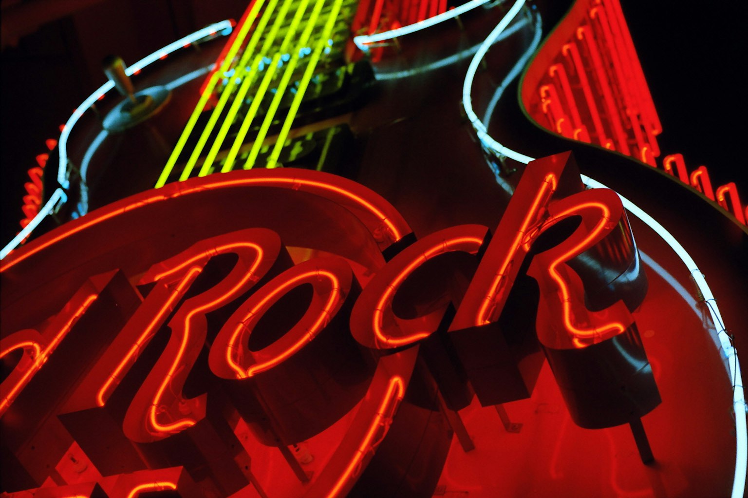 Primer plano de un letrero de neón con una guitarra y luces rojas y amarillas