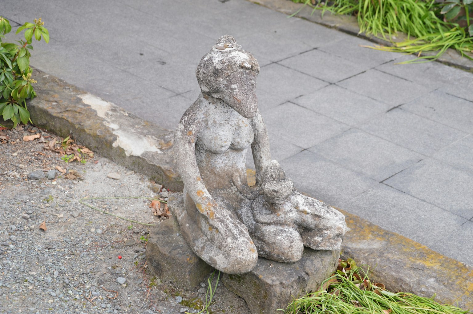 Statua in pietra di una madre seduta con un bambino