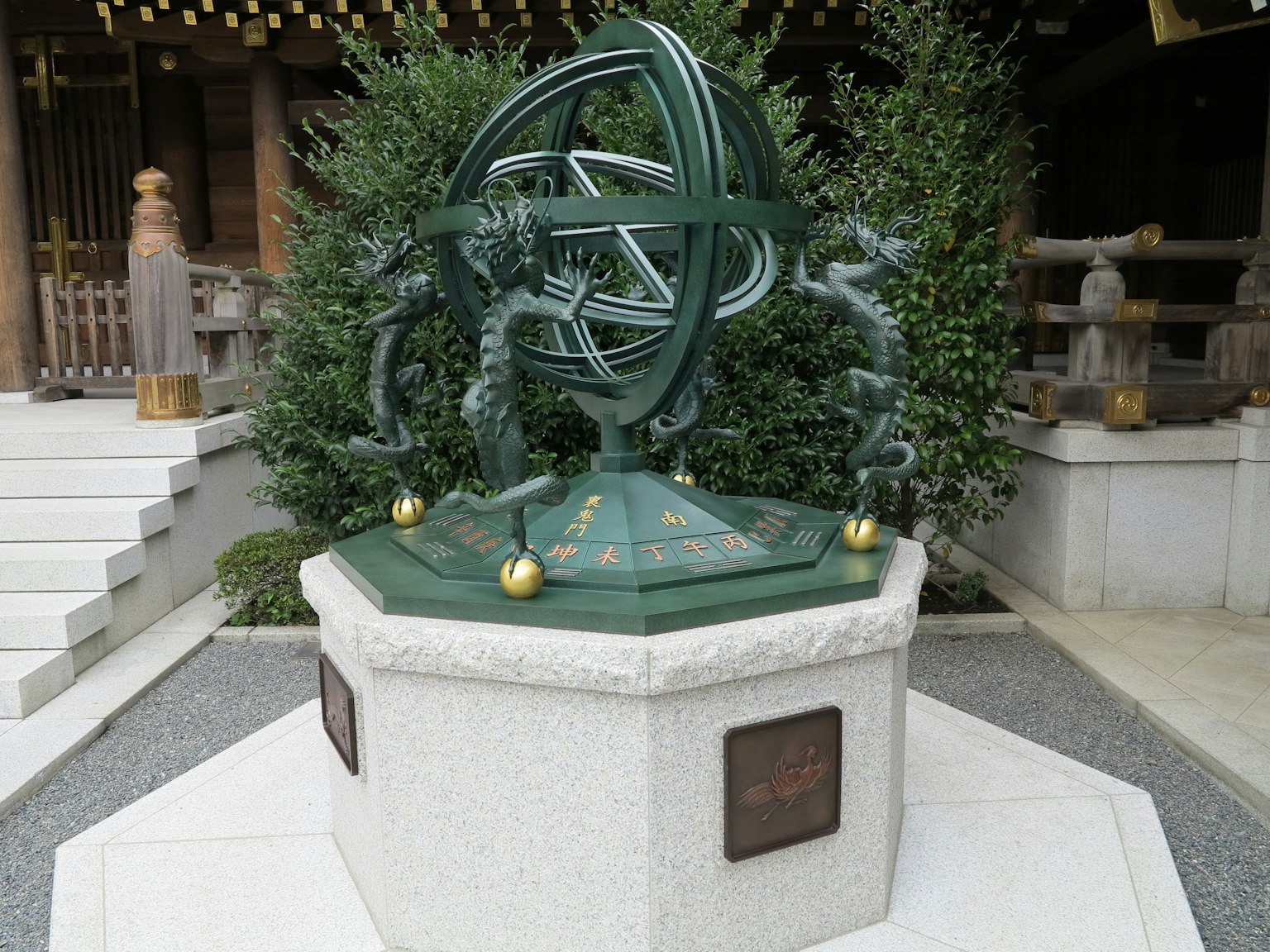 A beautiful green astronomical sculpture with decorative elements surrounding it