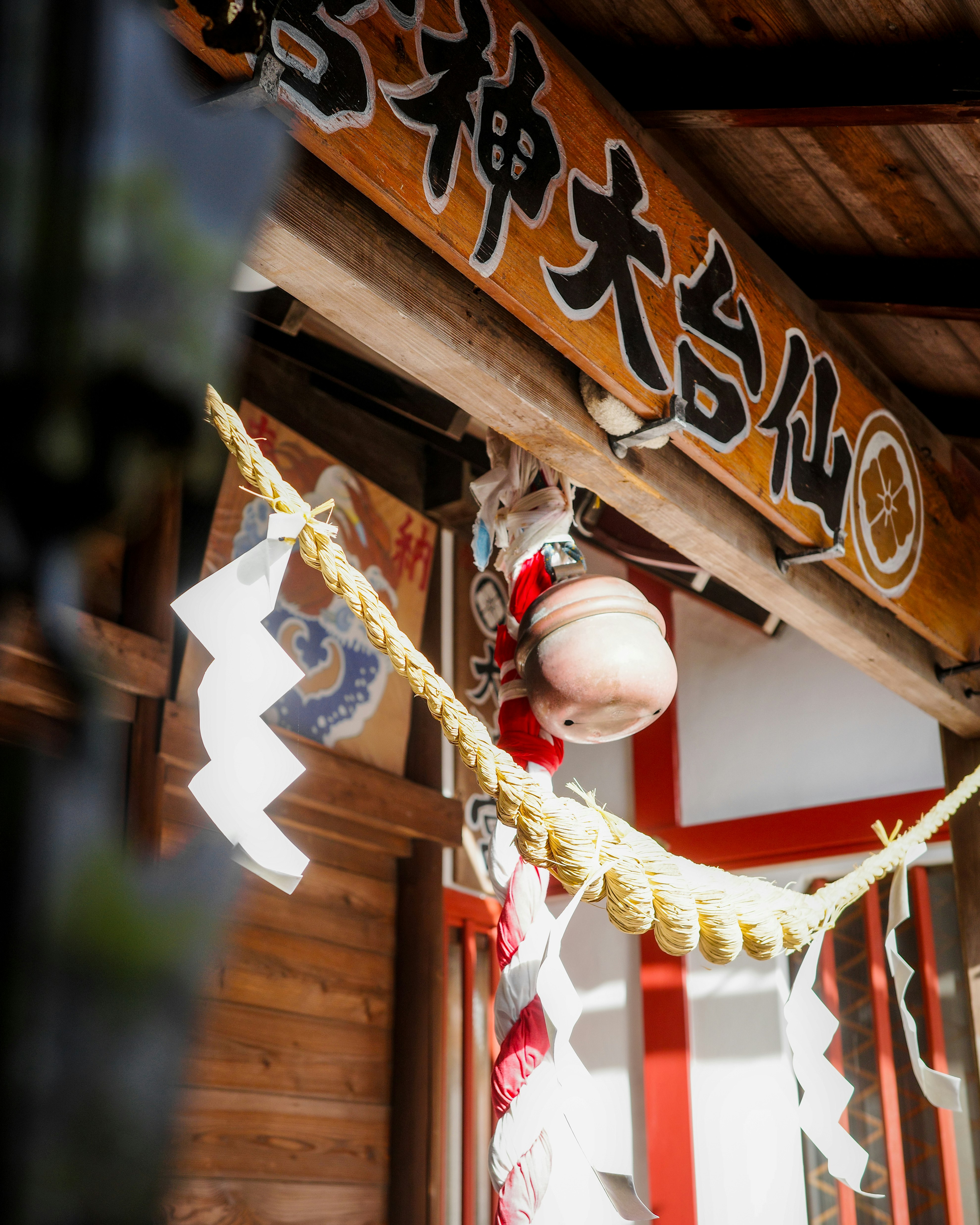 神社入口，木質屋簷下懸掛護符與燈籠