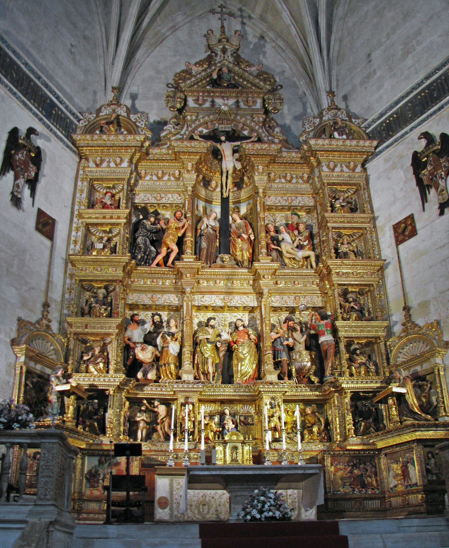 Autel élaboré avec des sculptures dorées et des figures religieuses dans une église