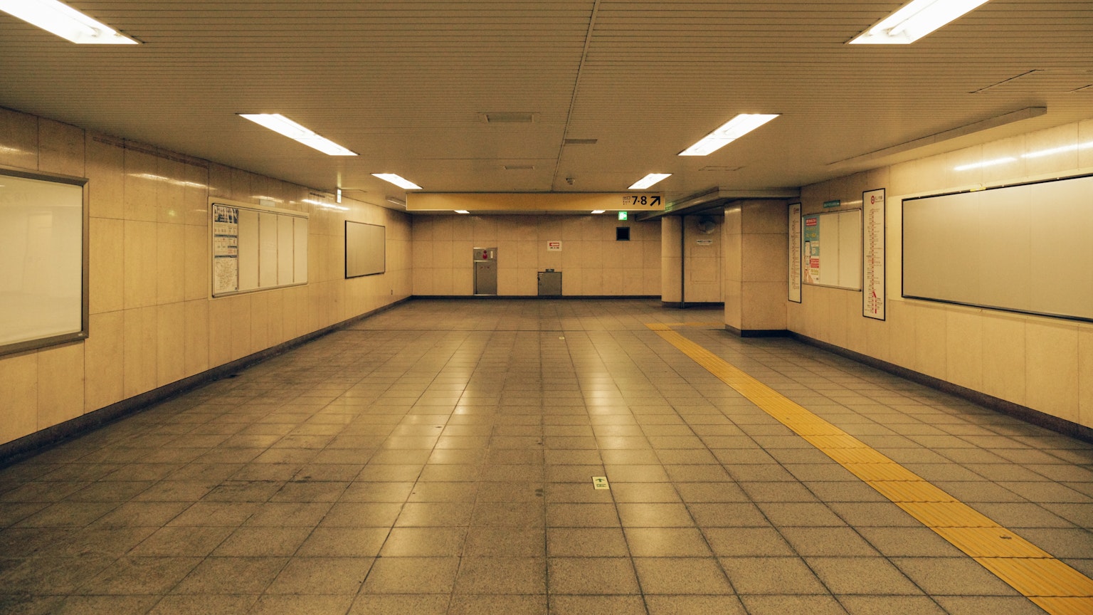 Passage souterrain vide avec un éclairage lumineux et un sol carrelé avec une ligne jaune