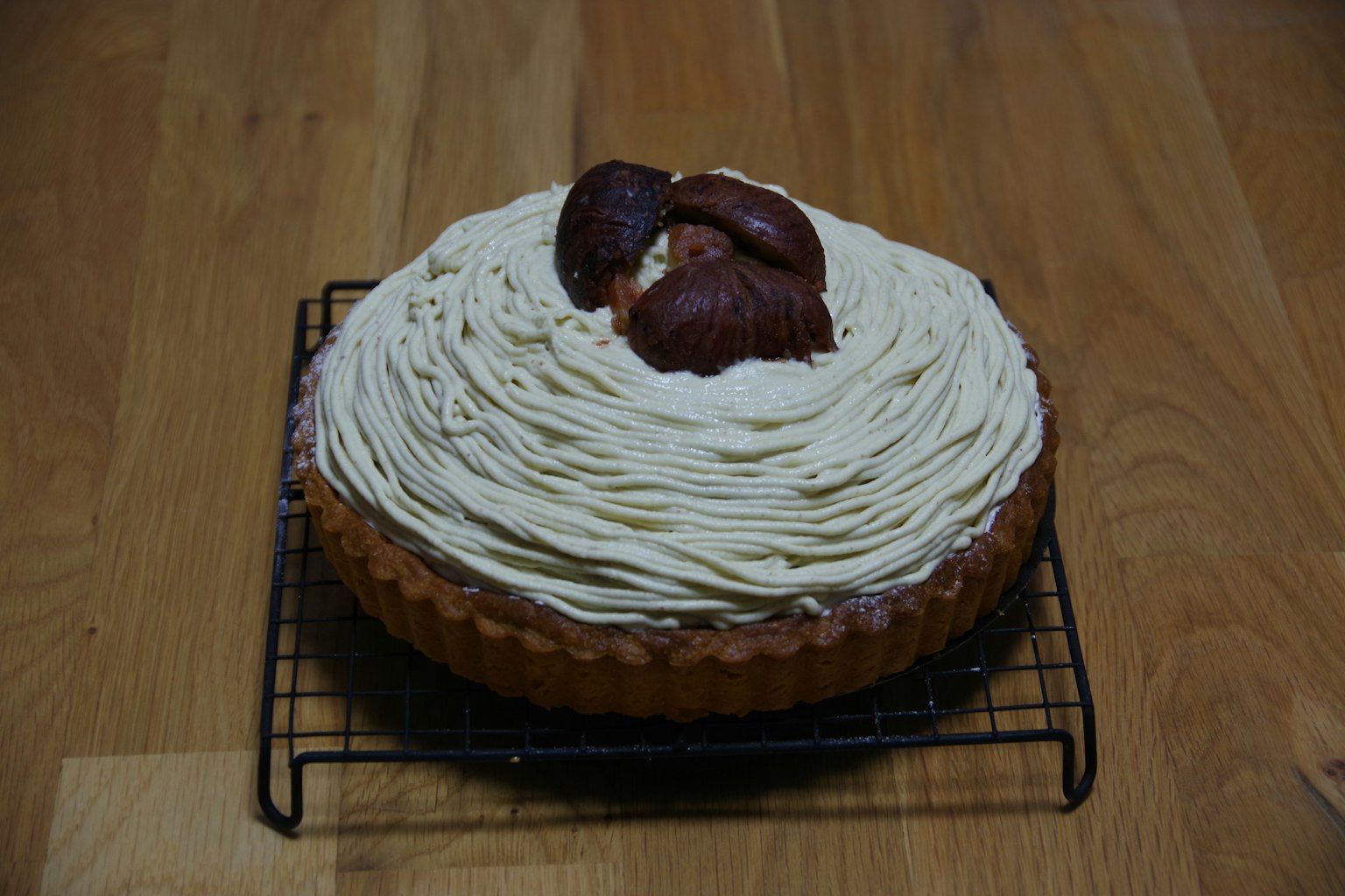 Kue gaya Mont Blanc yang dihiasi krim diletakkan di atas rak kawat