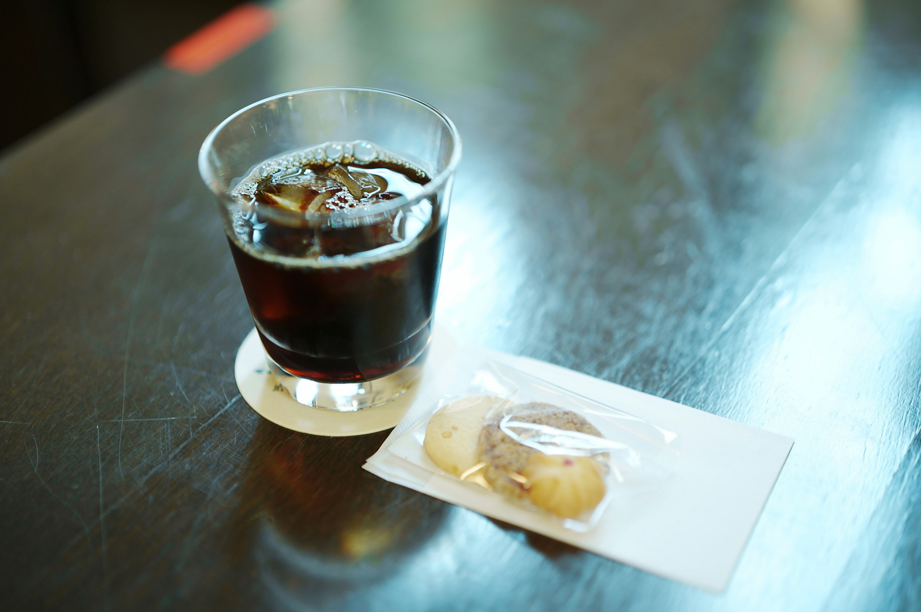 Un bicchiere di caffè con una piccola pasticceria su un tavolo