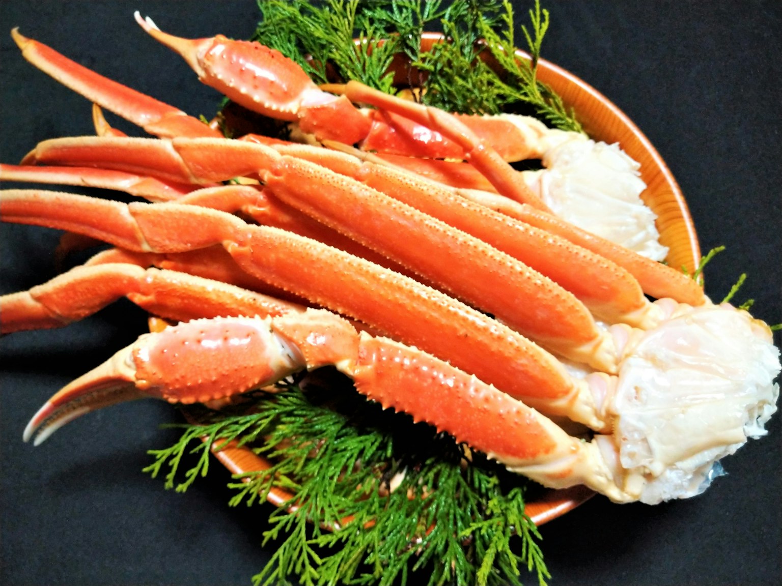 Kaki kepiting segar disusun di atas daun hijau
