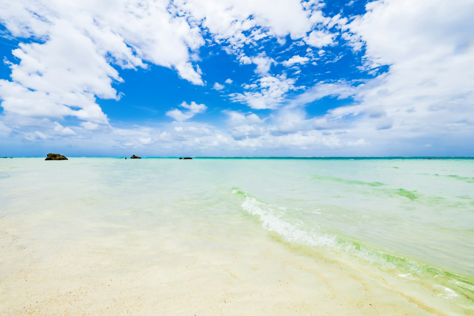 ทิวทัศน์ชายหาดที่สวยงามกับท้องฟ้าสีฟ้าและทรายขาว