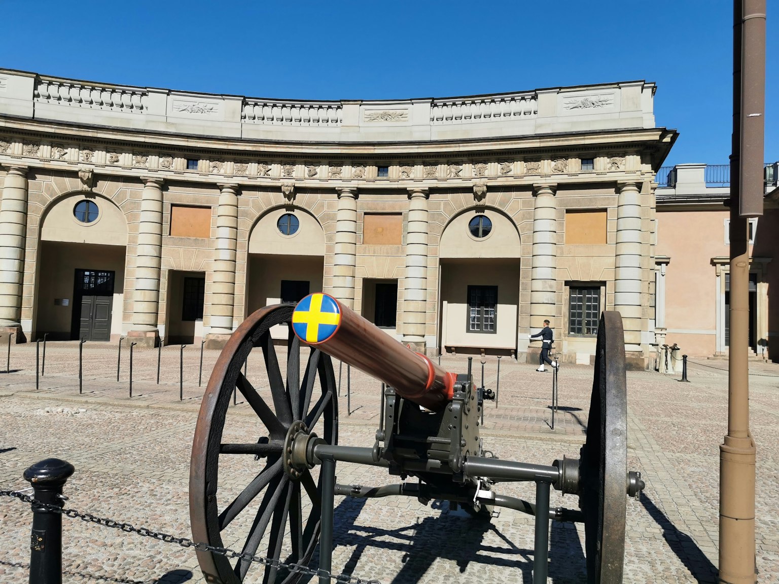 Edificio histórico con un cañón que presenta la bandera sueca