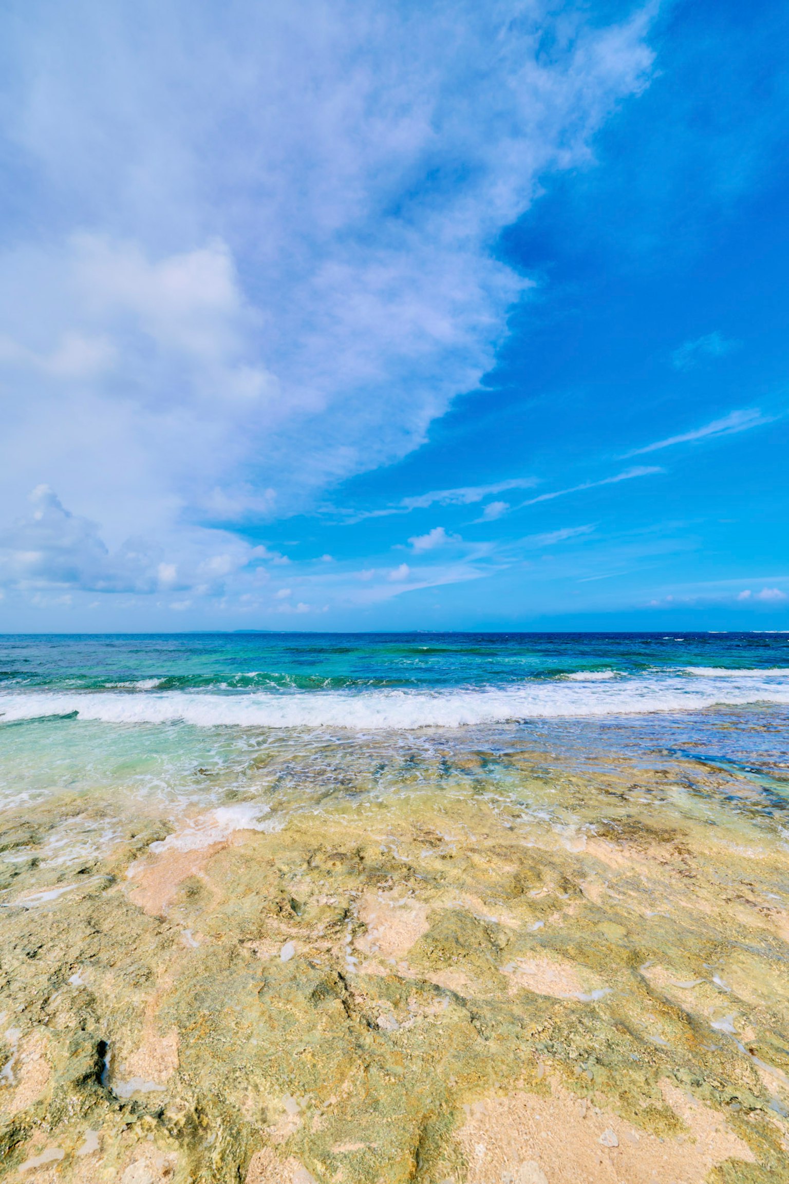 Panorama des blauen Ozeans und Himmels mit sichtbaren flachen Felsen