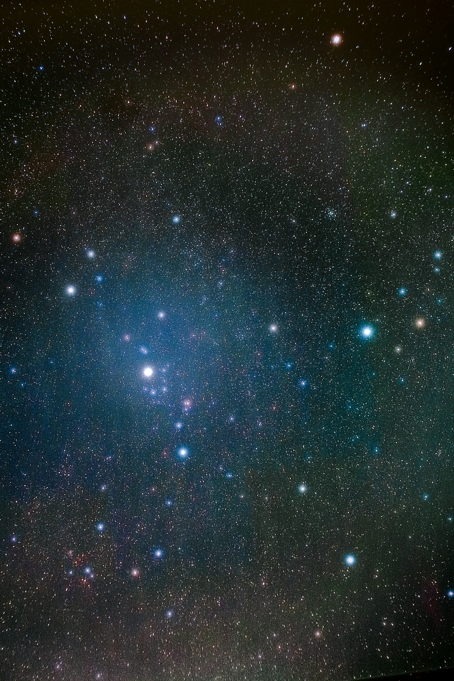 Image of a starry sky featuring bright stars and a blue nebula