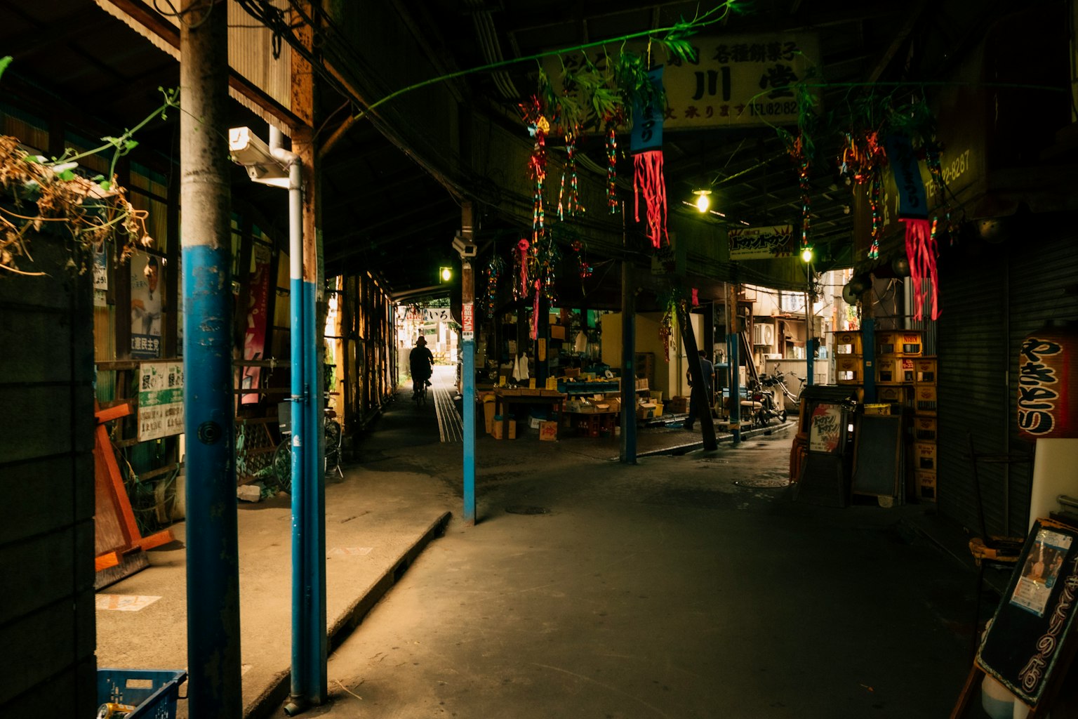 狹窄的小巷，懸掛著彩色裝飾和展示各種商品的商店