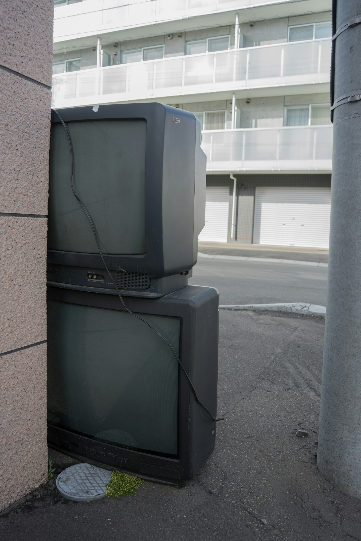 Dos viejos televisores apilados en una esquina
