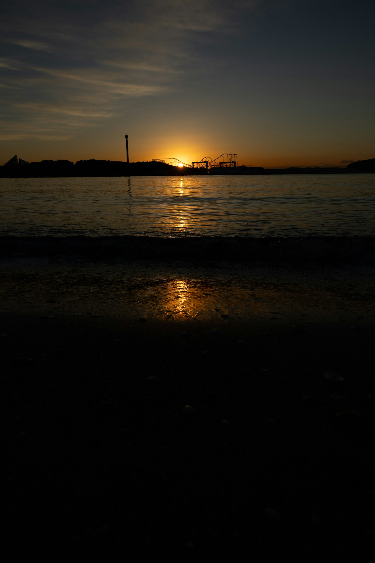 Puesta de sol reflejándose en la superficie del agua en la playa