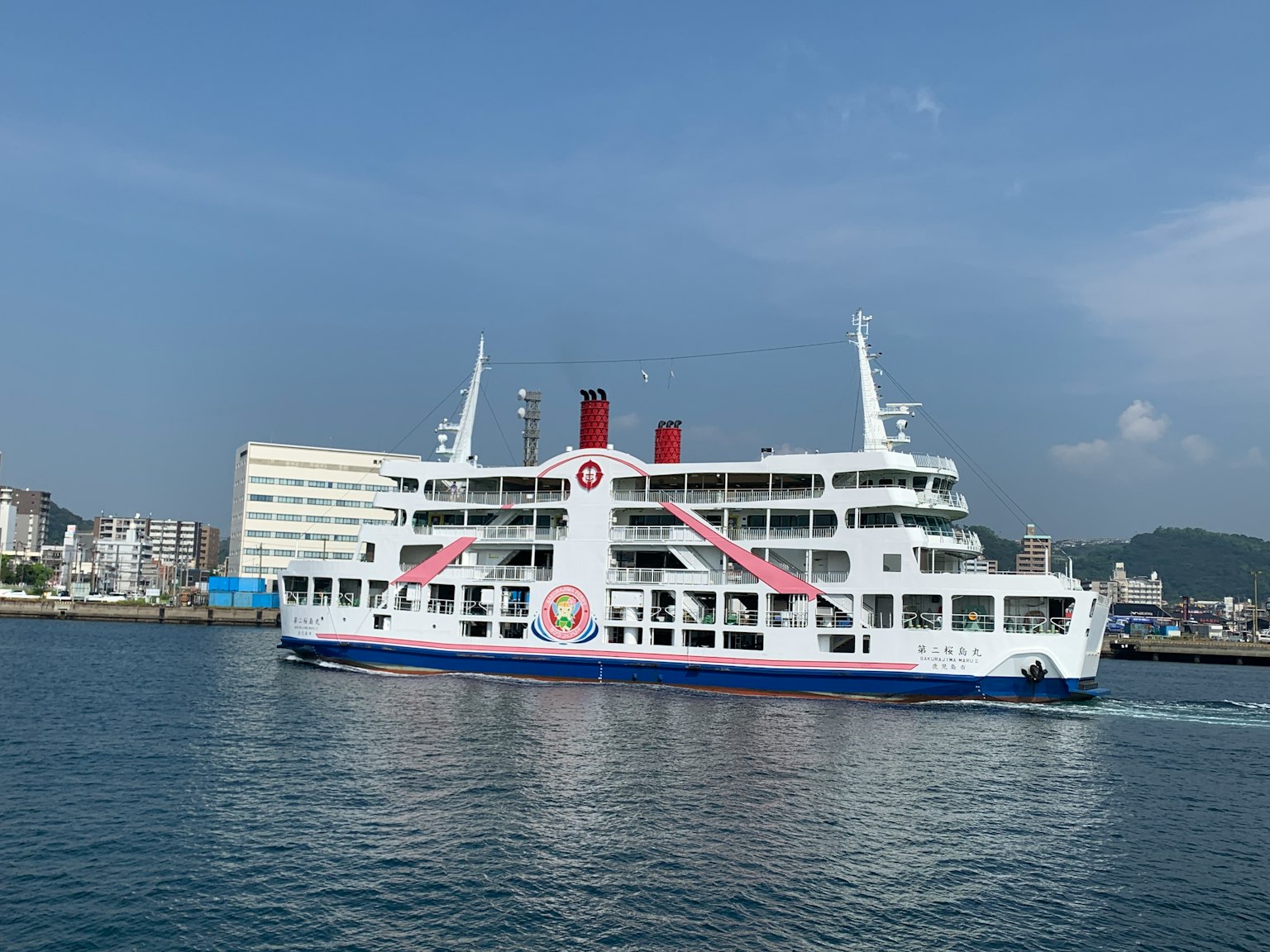 Un ferry blanco saliendo del puerto contra un mar azul