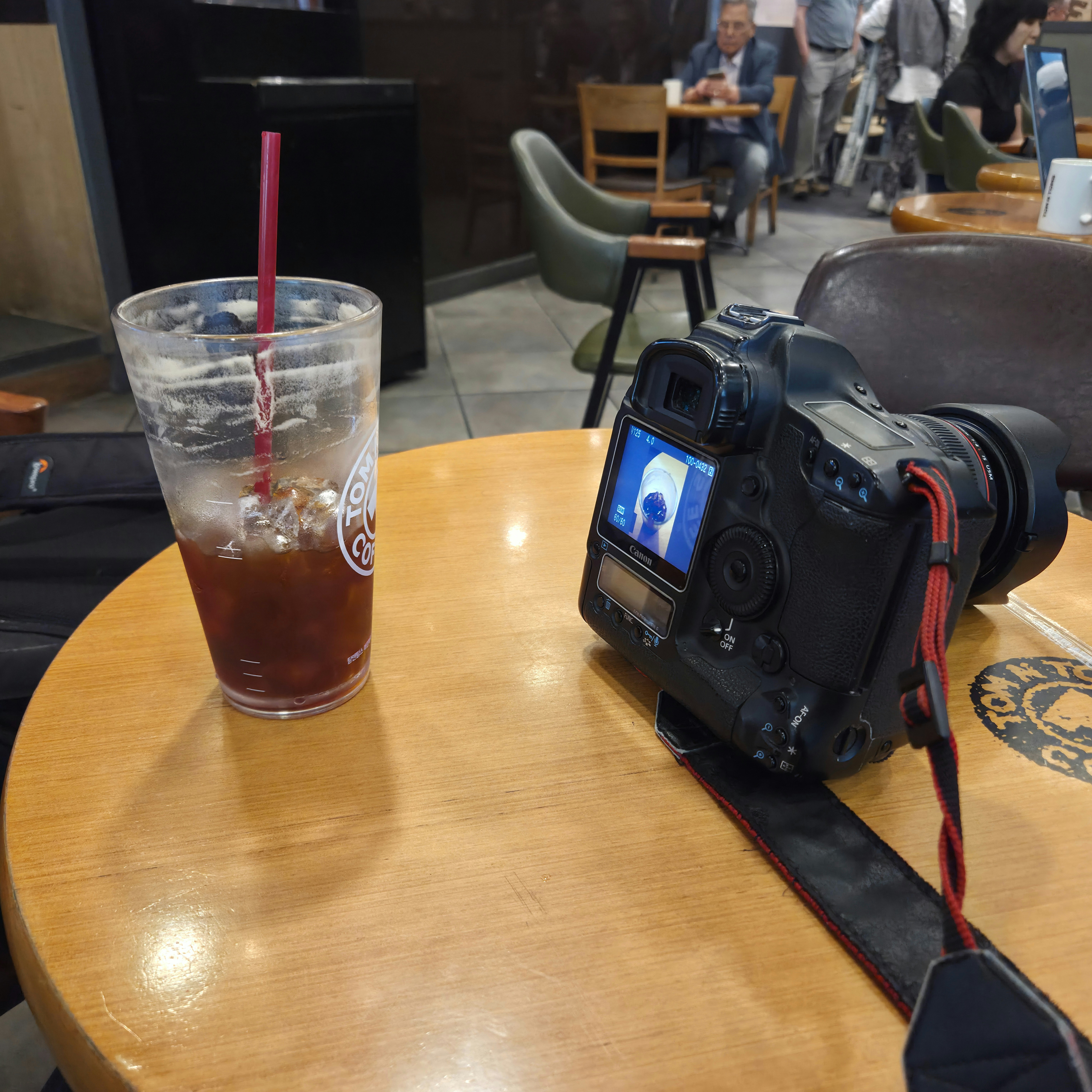 カフェのテーブルで飲み物とカメラが並ぶ