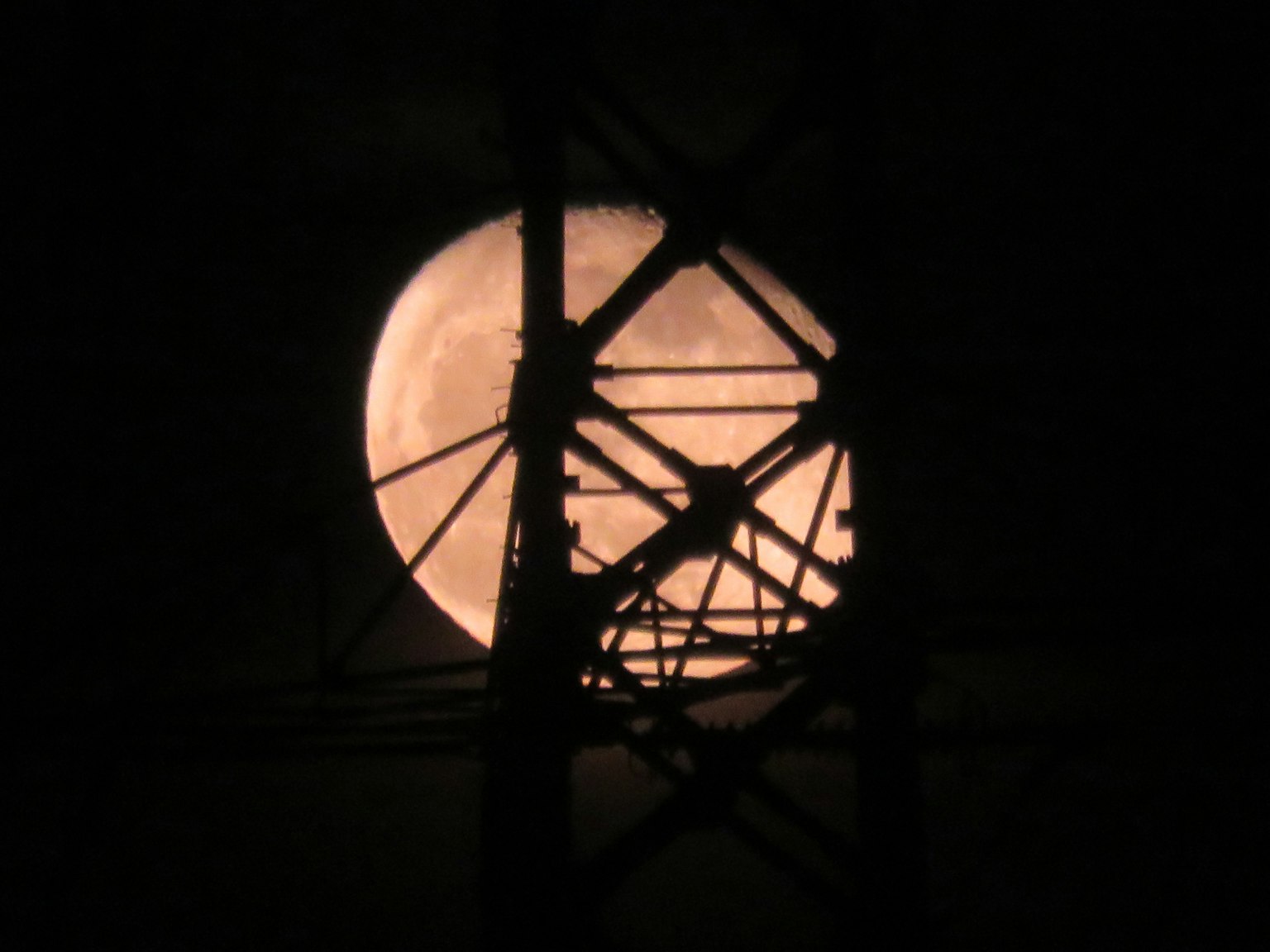 Un hermoso cielo nocturno con la luna visible entre las líneas eléctricas