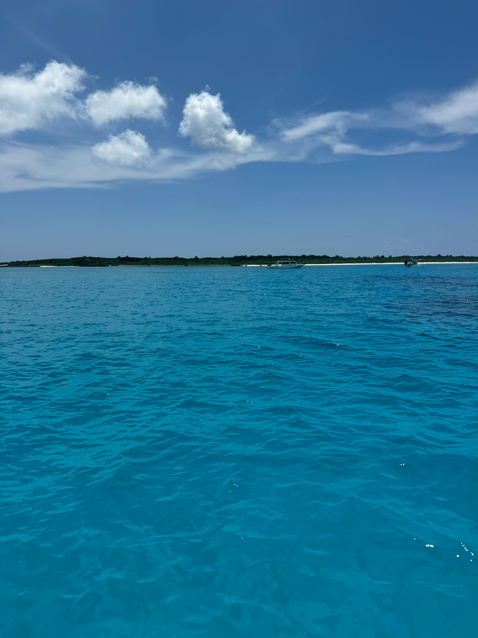 Mar turquesa vibrante bajo un cielo azul claro