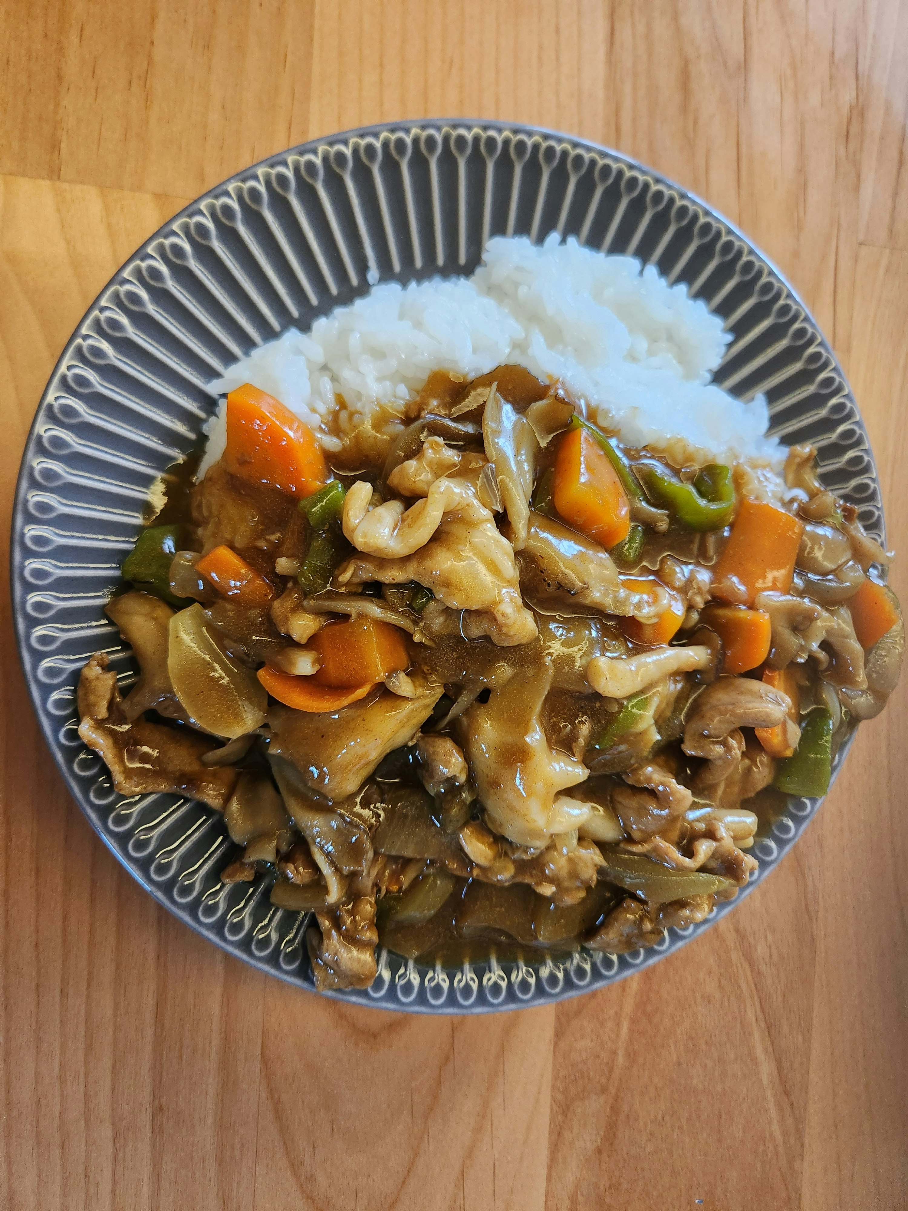 木目のテーブル上の野菜ときのこの煮込み料理