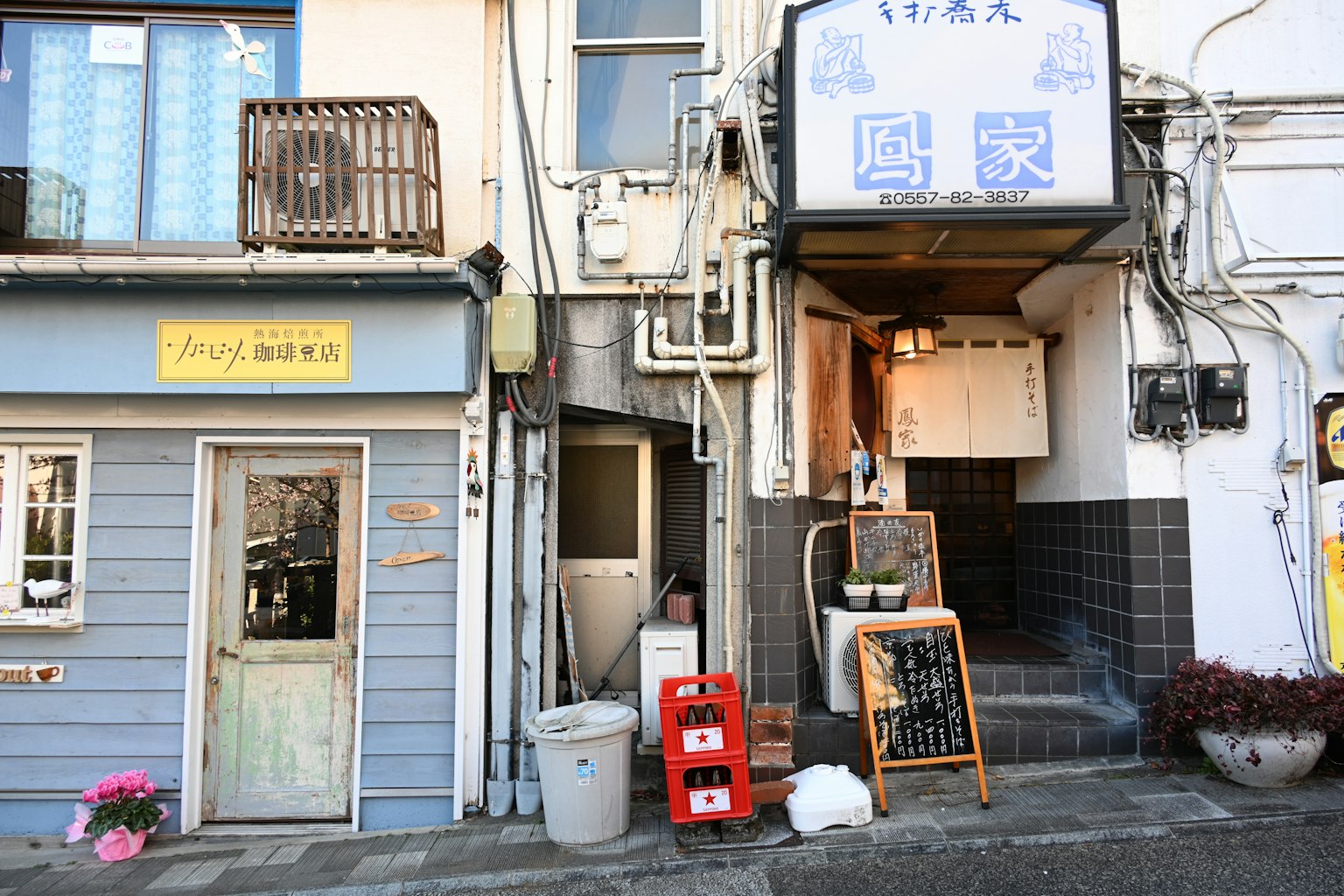 Scène de rue japonaise ancienne avec un café aux murs bleus et une brasserie traditionnelle adjacente