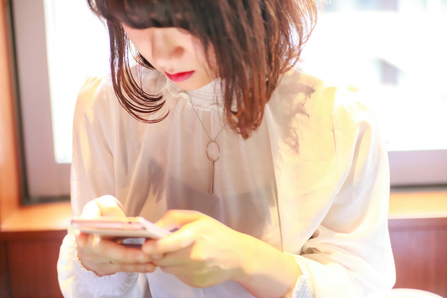 Femme jeune en blouse blanche utilisant un smartphone