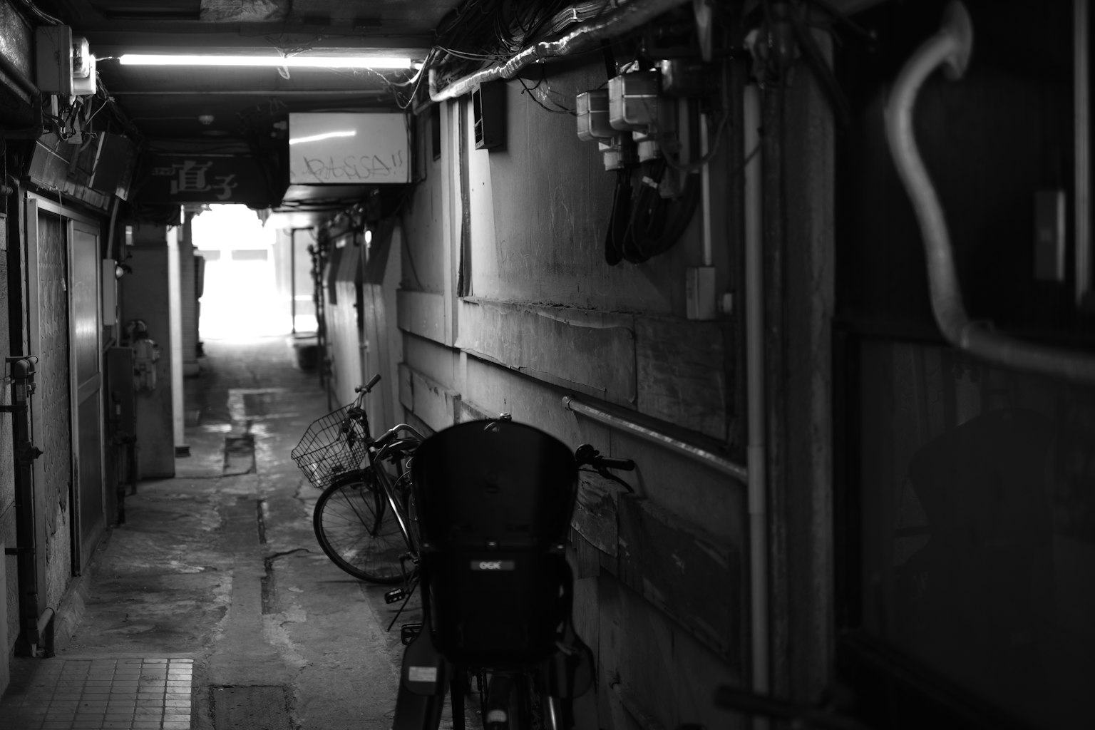 Callejón estrecho con una bicicleta en un entorno en blanco y negro