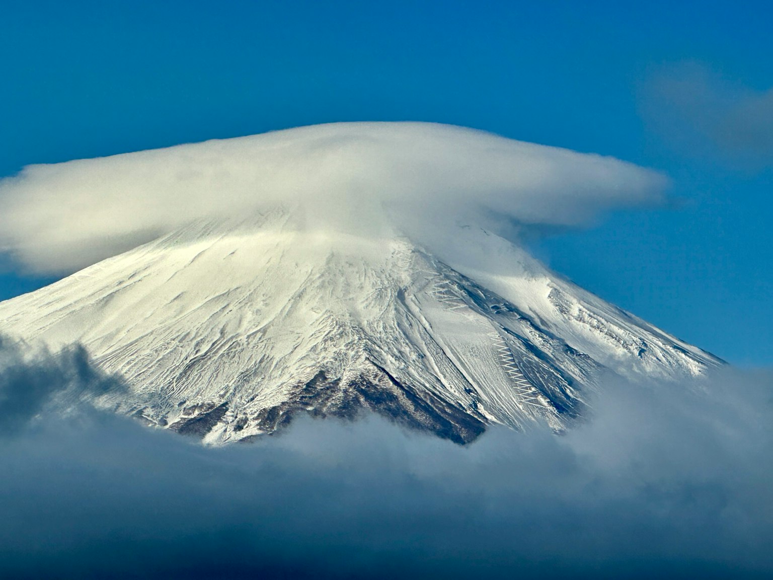Monte Fuji cubierto de nieve con una nube en la cima