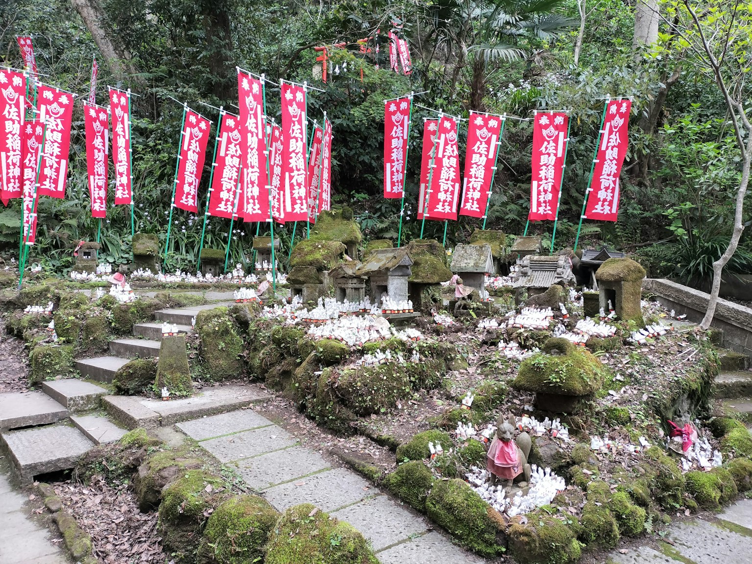 Une scène de sanctuaire avec des marches en pierre et un sol recouvert de mousse avec des bannières rouges