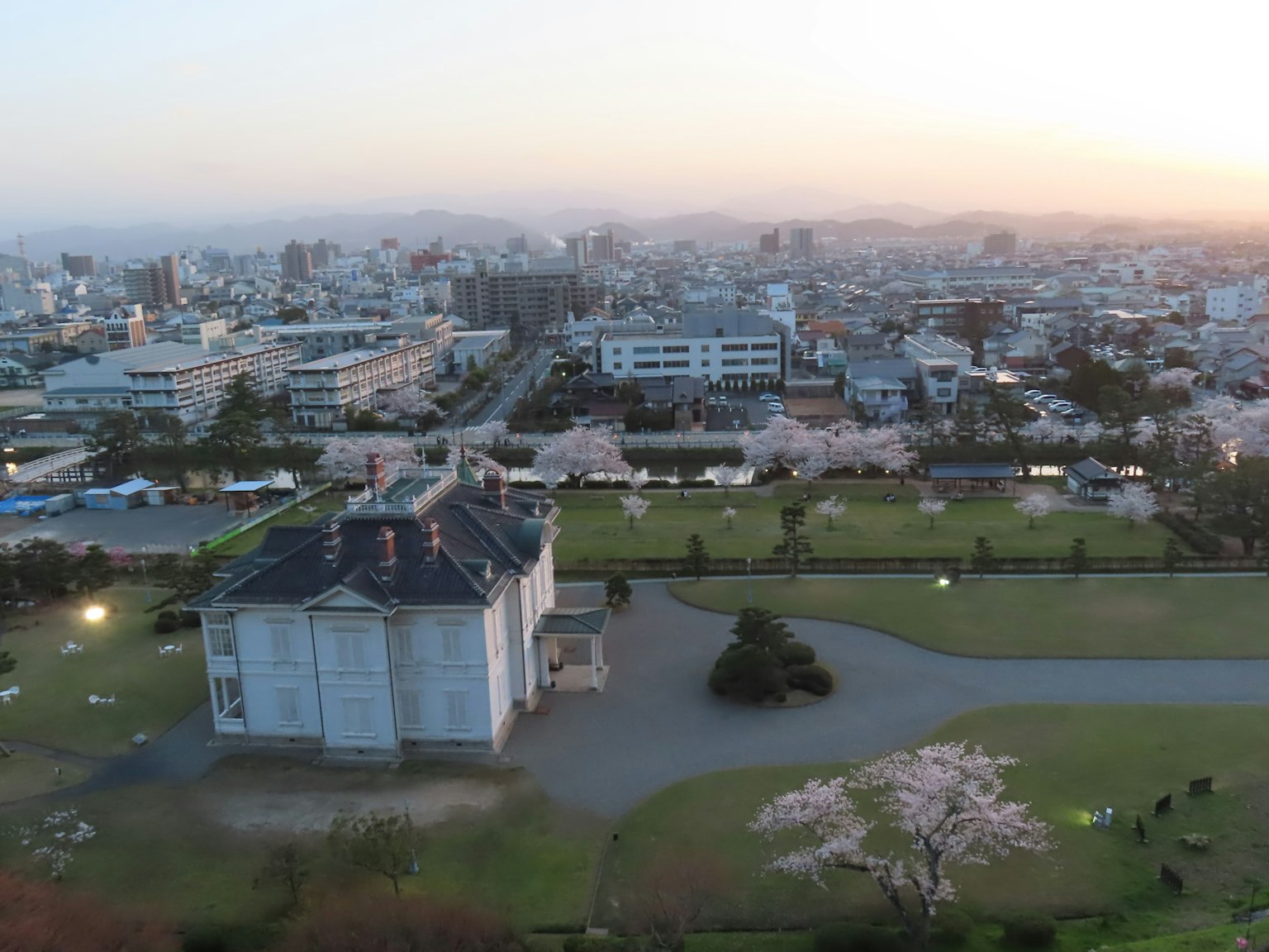Panorama urbano al crepuscolo con ciliegi in fiore e un edificio storico
