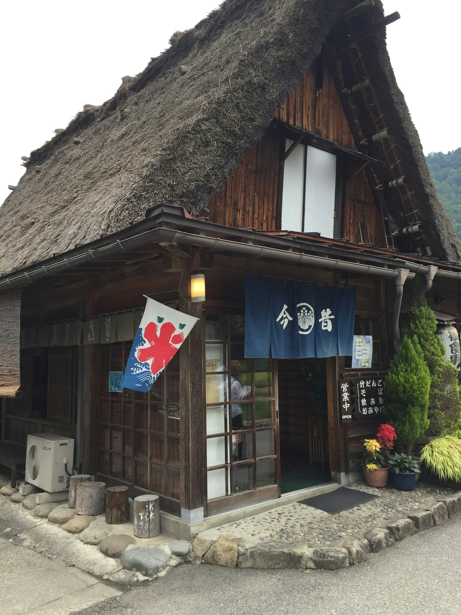 Eksterior rumah tradisional Jepang dengan atap rumbia dan struktur kayu