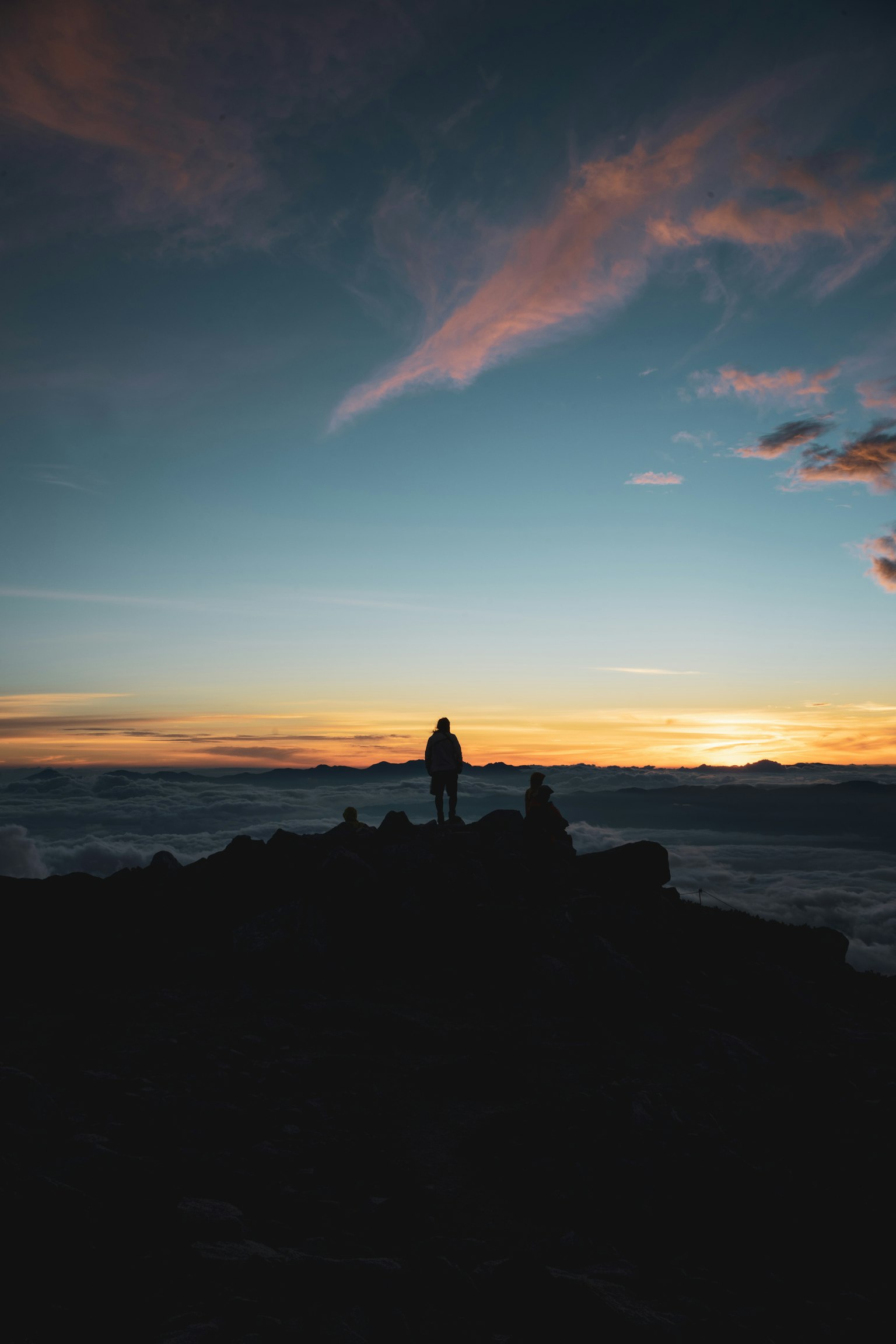 Silhouette di una persona in piedi contro un cielo al tramonto