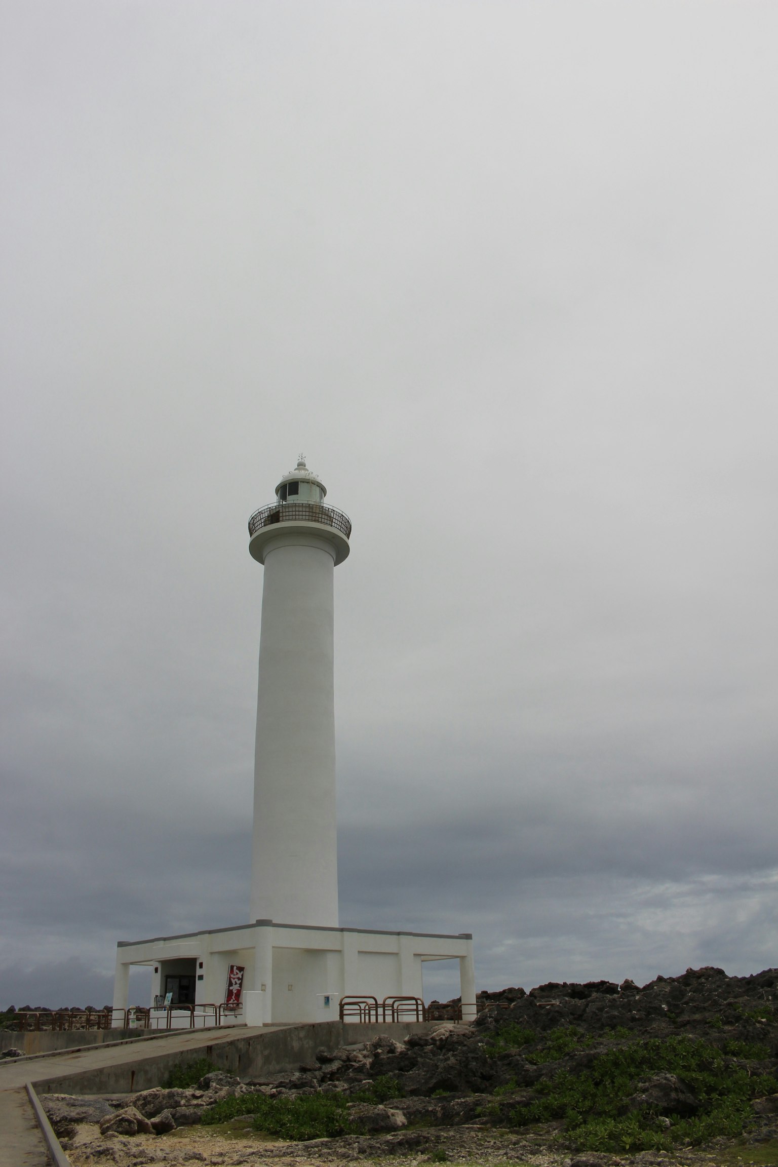Un faro blanco que se encuentra bajo un cielo nublado