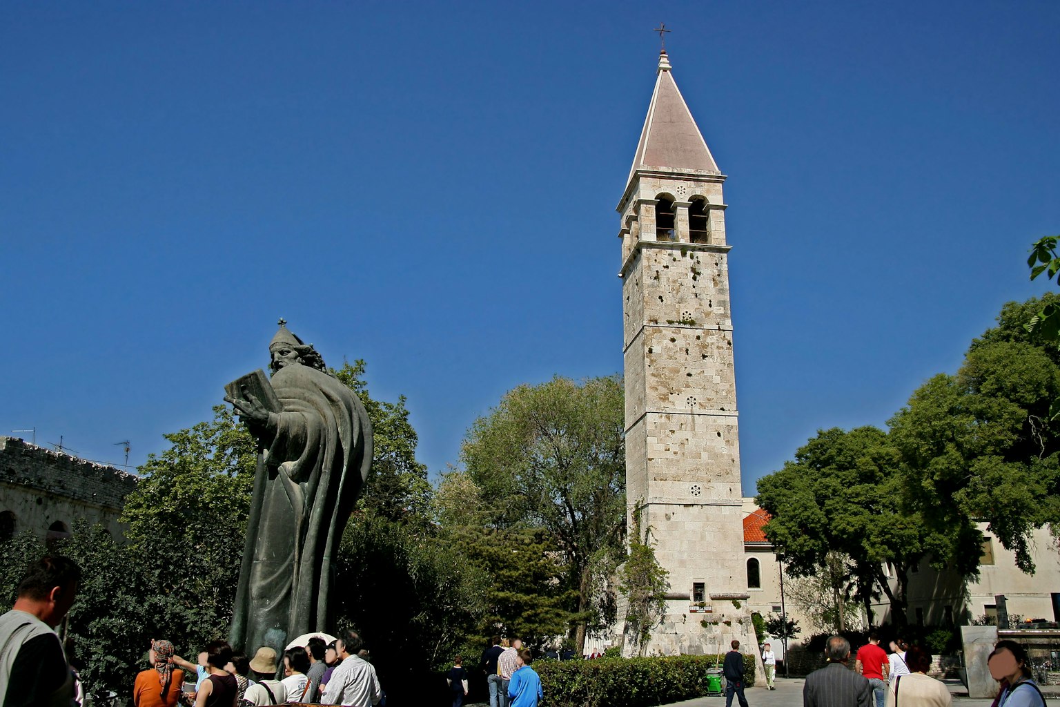 Landscape featuring a historic tower and statue in a square