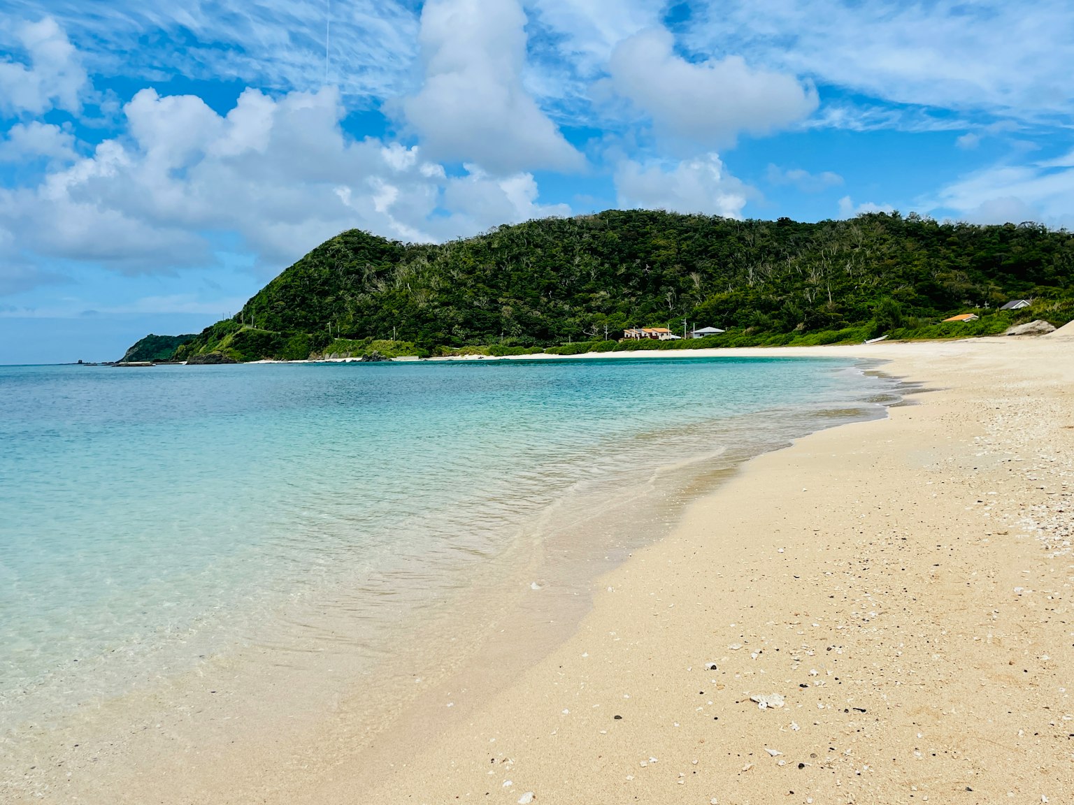 ทิวทัศน์ชายหาดที่มีทะเลสีน้ำเงินใสและชายหาดสีขาว