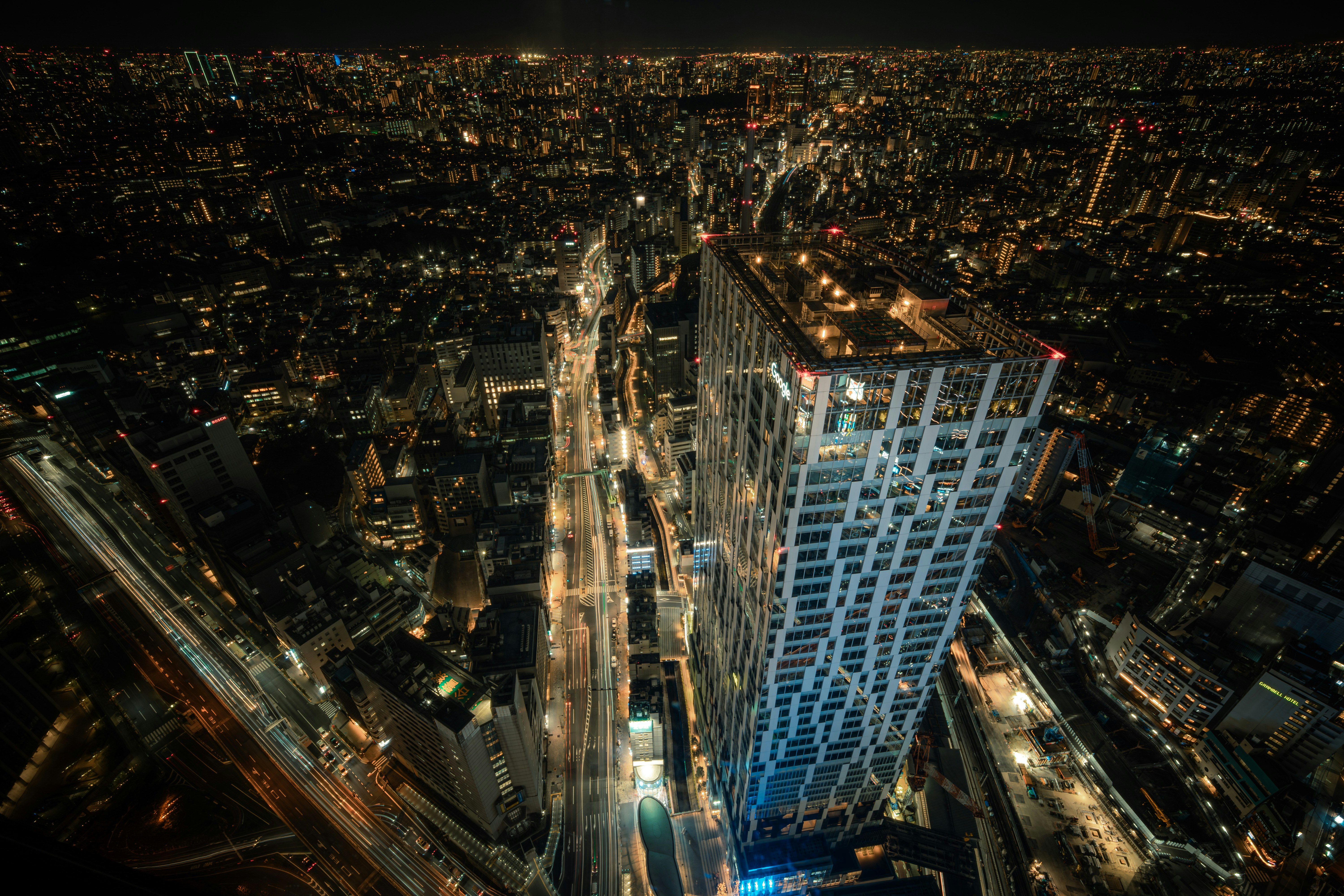 vista aérea de una avenida urbana de noche con rascacielos