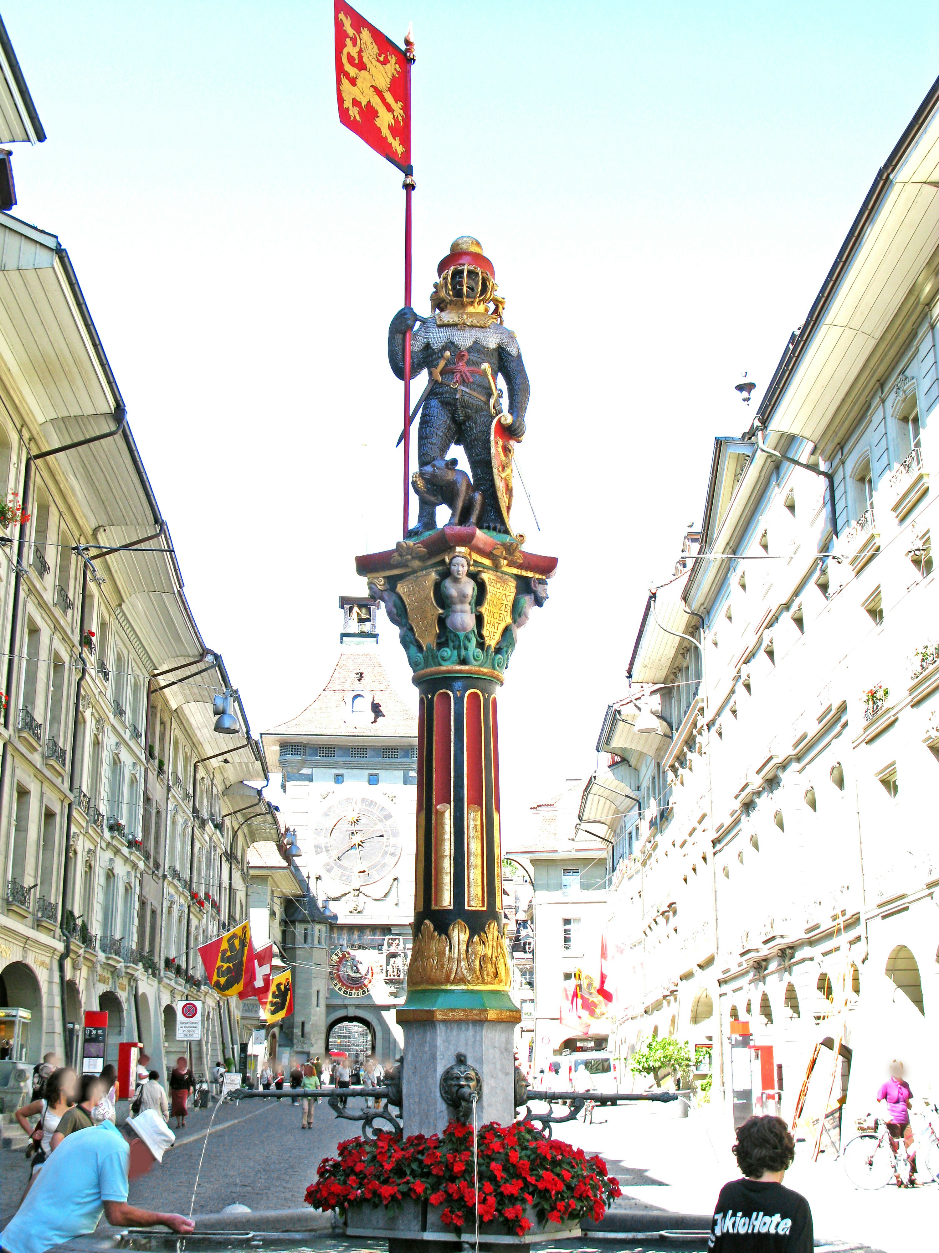 vue d’une rue avec une colonne décorative et des fleurs