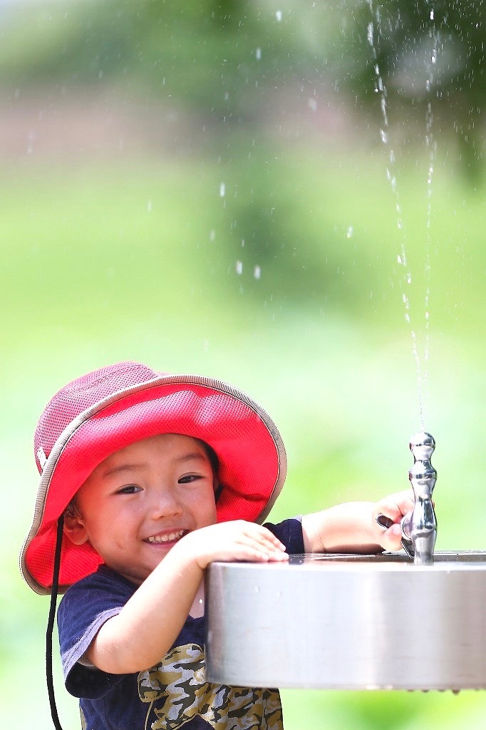 白鷺公園の水飲み場で遊ぶ子どもの水遊び