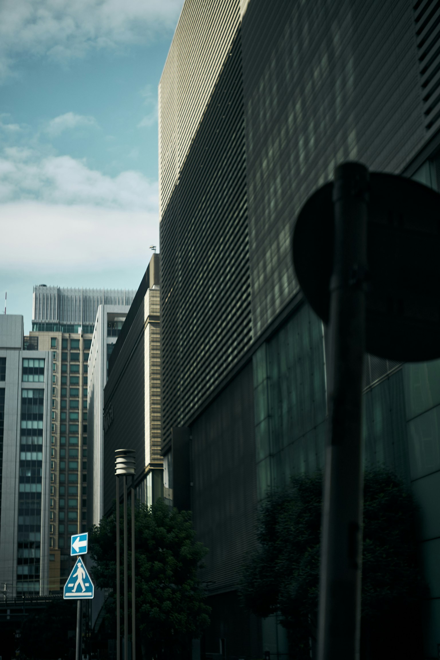 高層ビルの影が映る都市の風景 青空と雲が見える