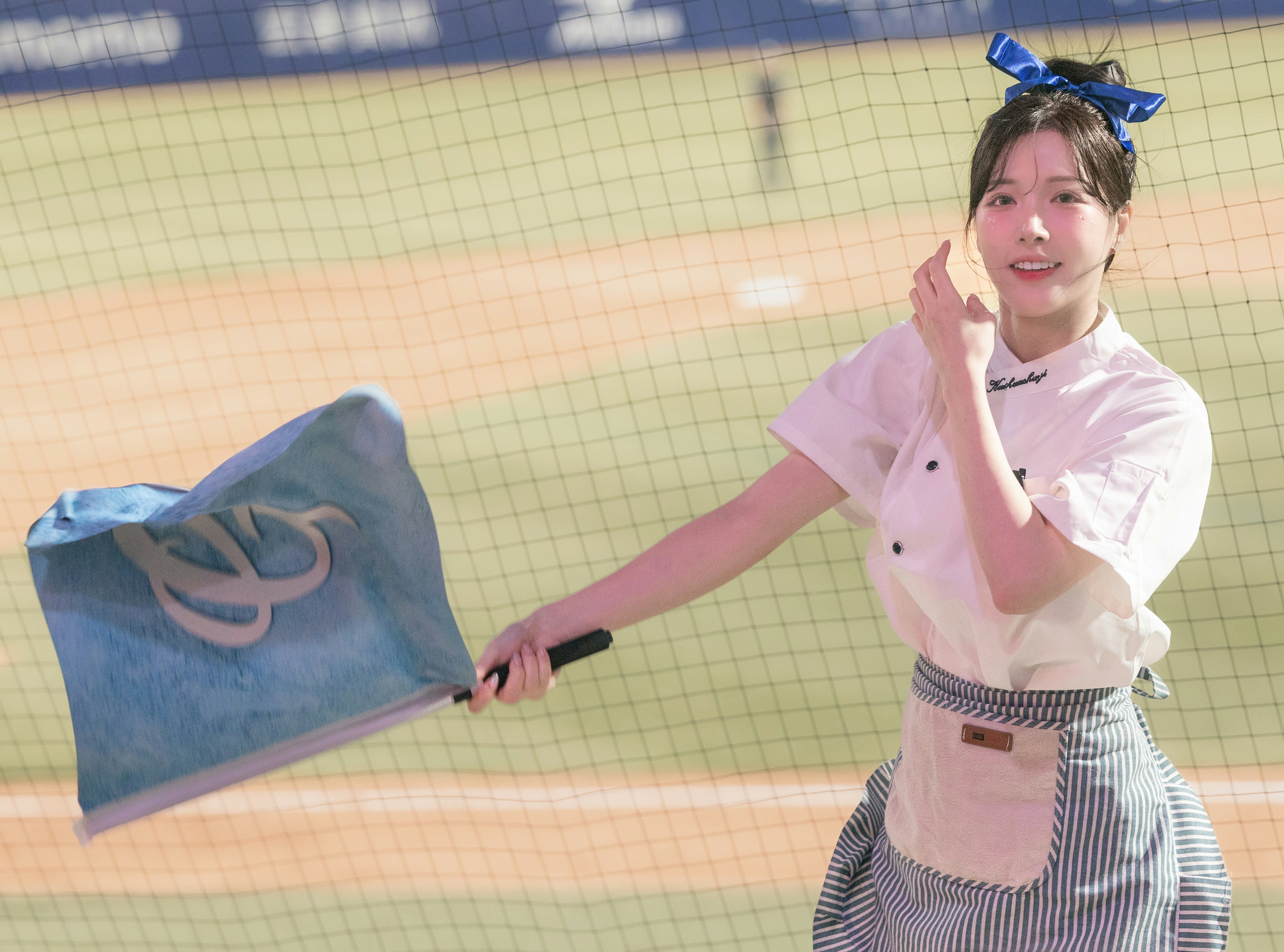 ピンクの衣装でポーズをとる女性と青い風船