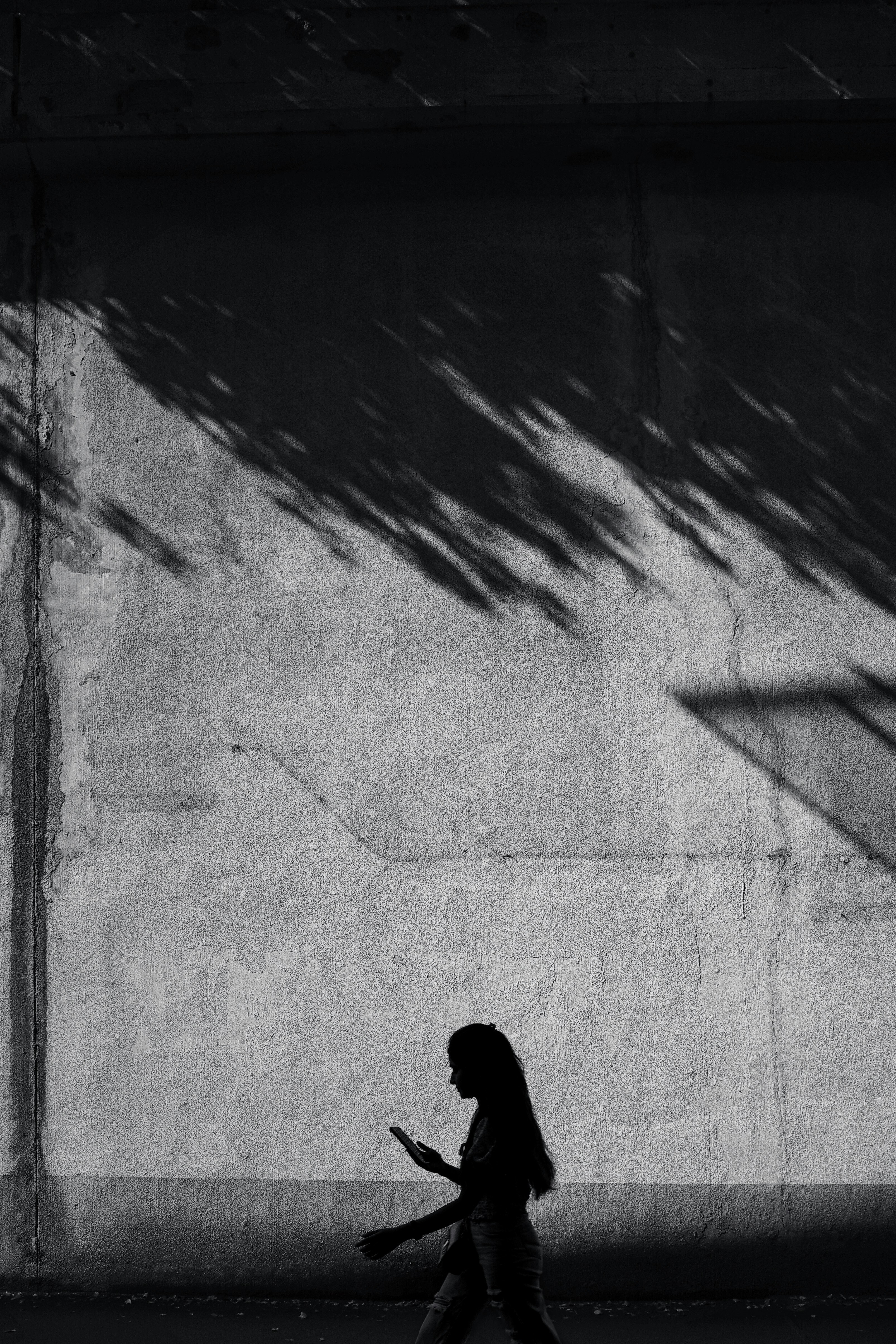 silhouette d’une personne marchant près des ombres sur un mur