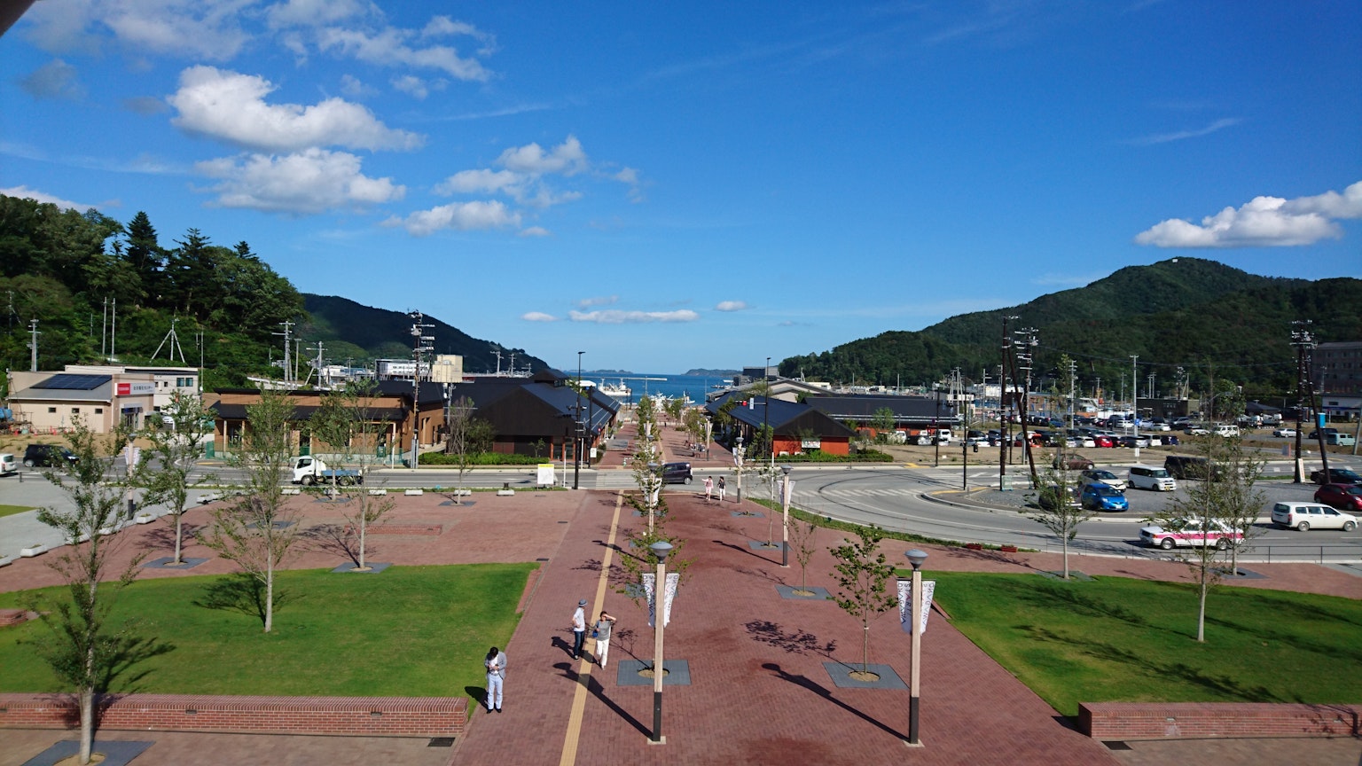 Scenic view of a park with a pathway under a blue sky and mountains in the background