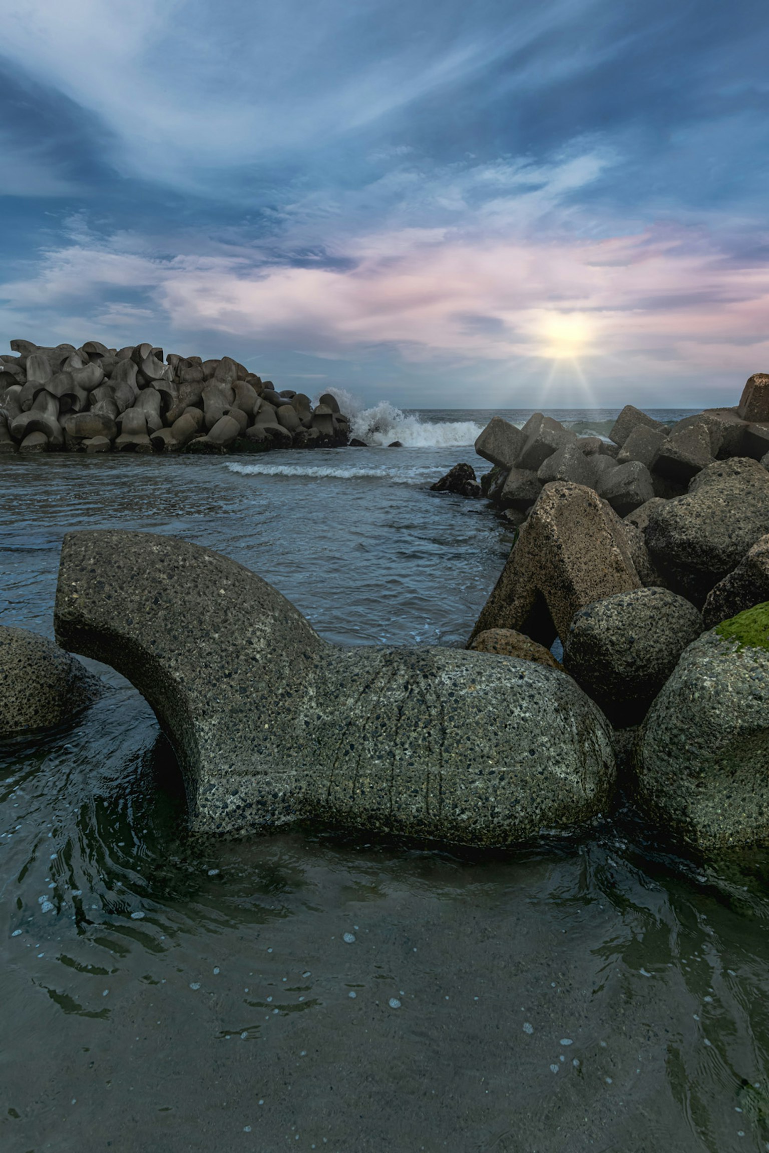 Rocas costeras con olas y un hermoso cielo al atardecer