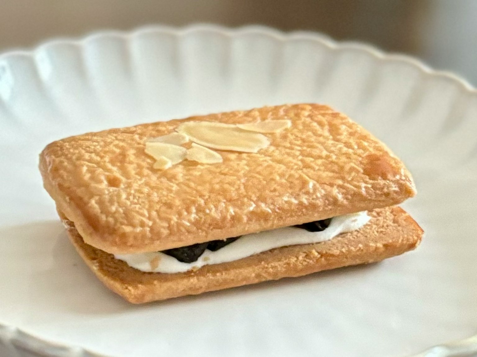 一塊薄餅夾著奶油和黑色碎片