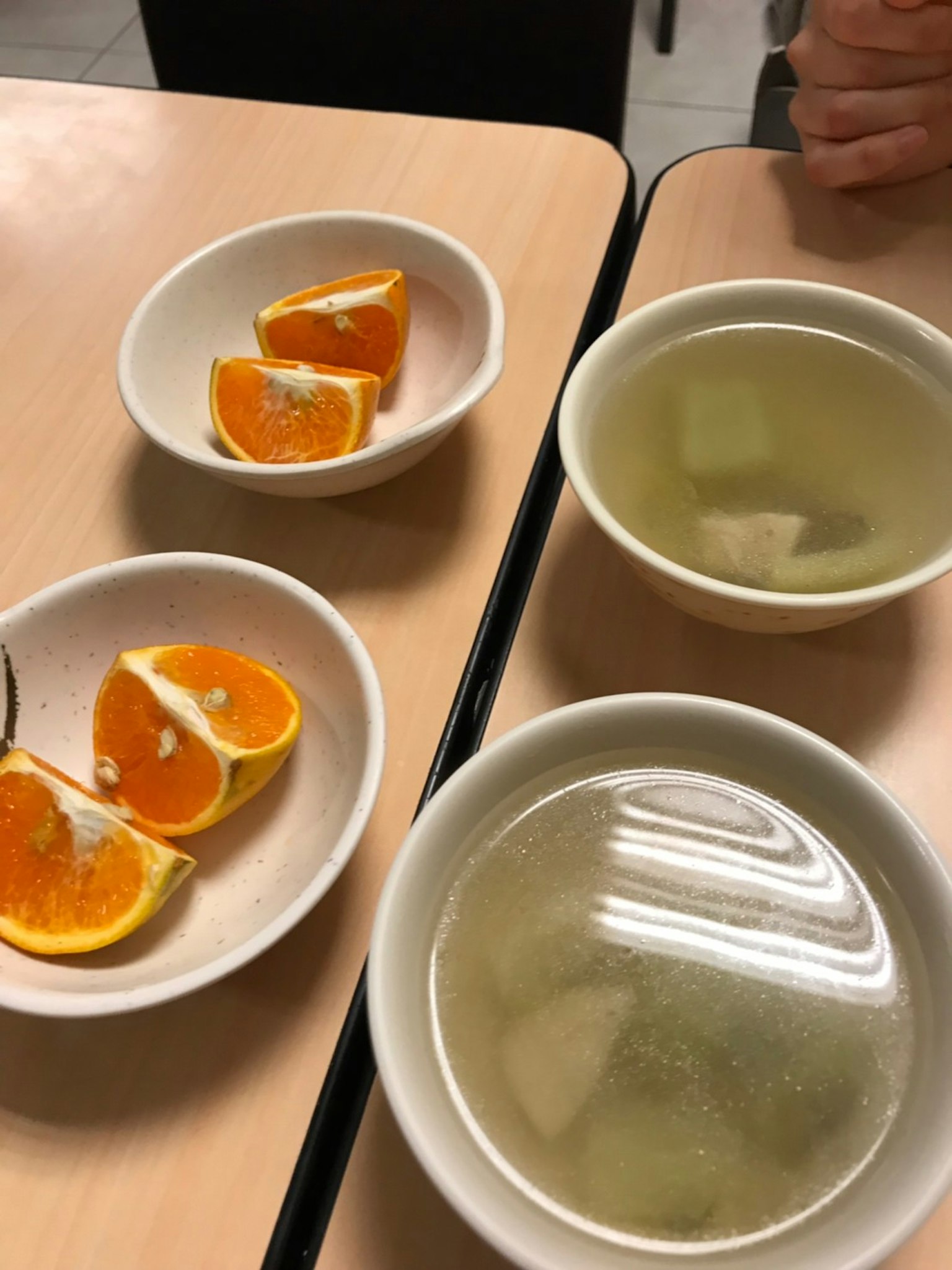 桌子上的橙子片和清汤碗