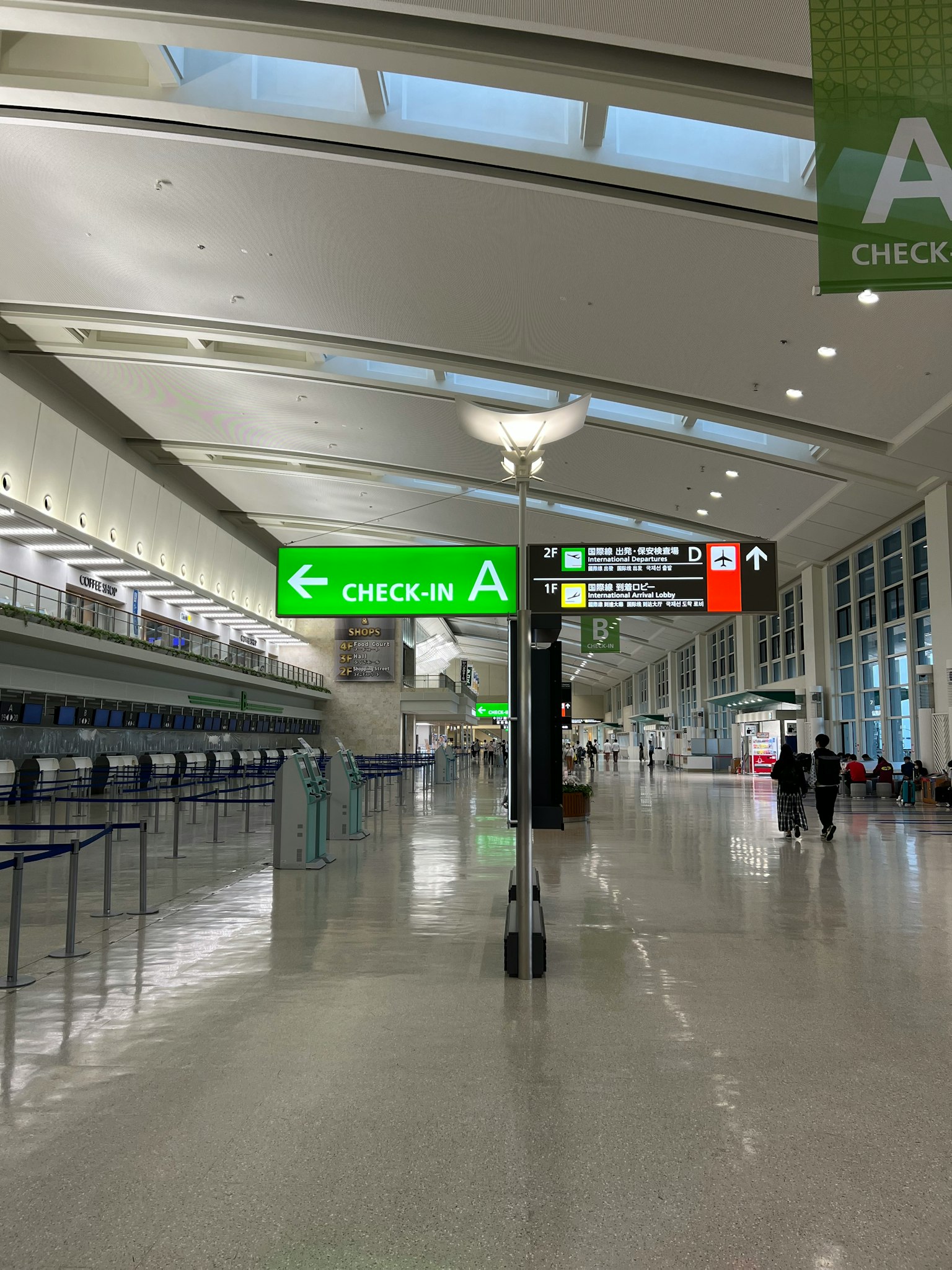 Vue intérieure d'une zone d'enregistrement d'aéroport avec un panneau d'enregistrement vert et un éclairage lumineux