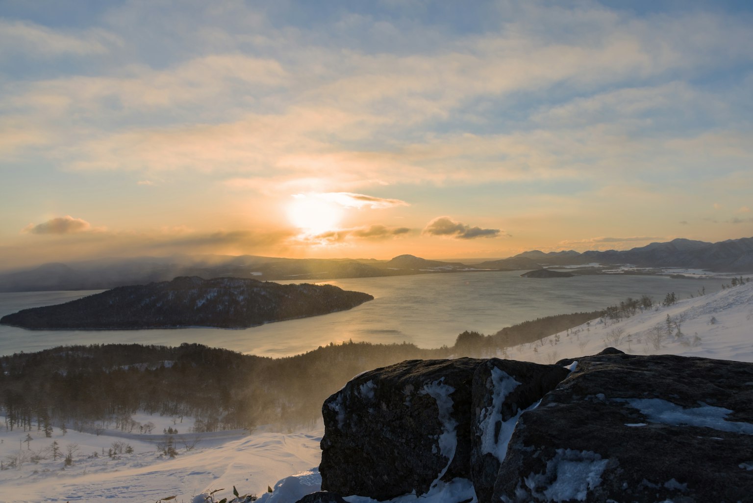 Beautiful sunset landscape over snowy mountains and lake