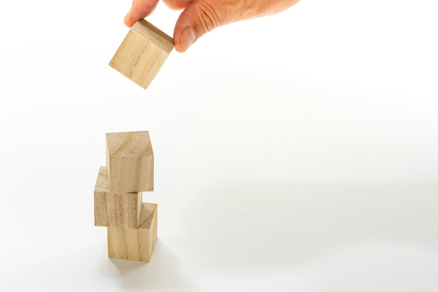 Image of a hand stacking wooden blocks