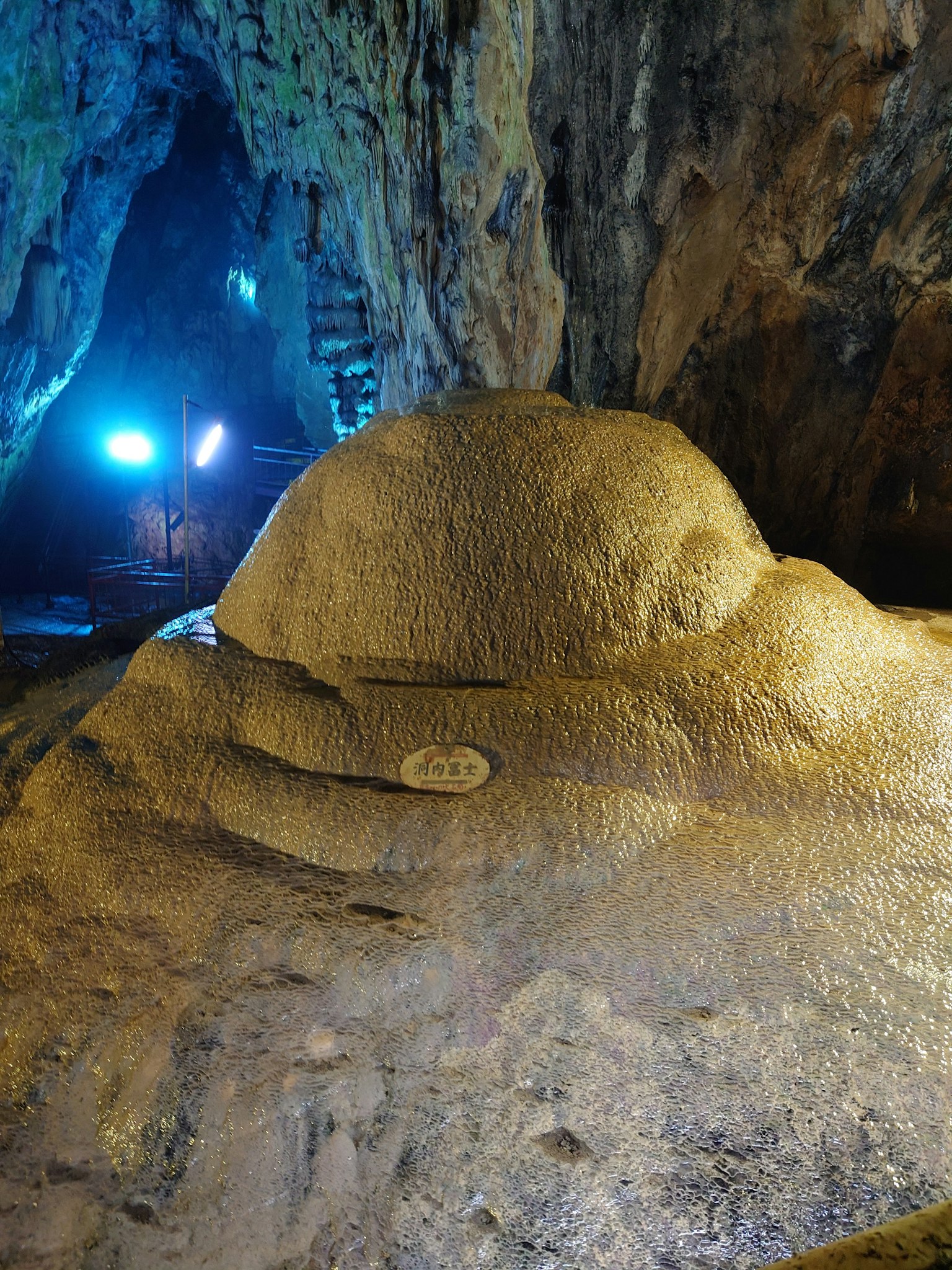 Große Felsformation in einer Höhle, beleuchtet von blauen Lichtern