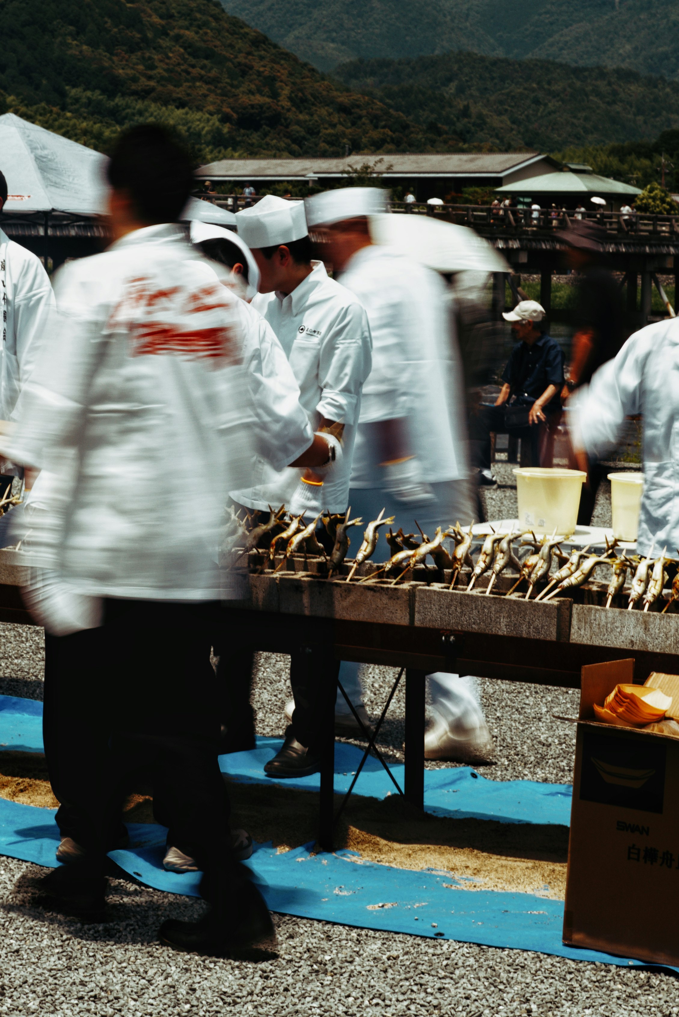 bancarelle all’aperto del festival Arashiyama Wakayu con ayu alla griglia e vista sul ponte Togetsukyo