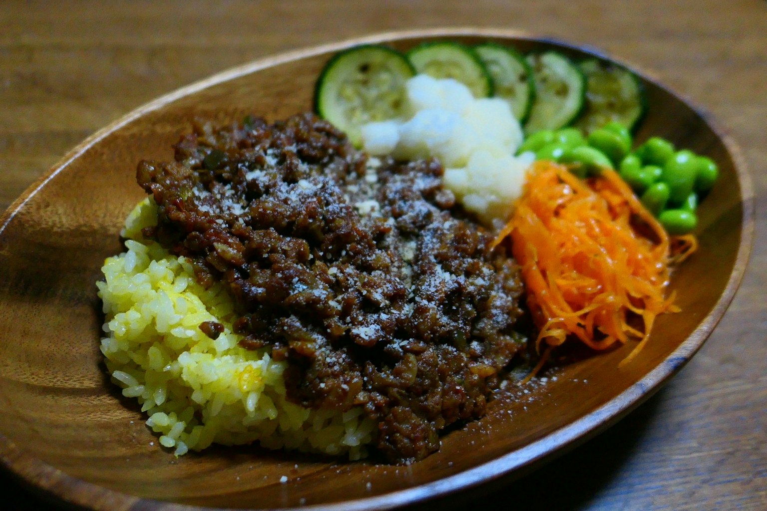A plate of seasoned ground meat served over rice with assorted vegetables