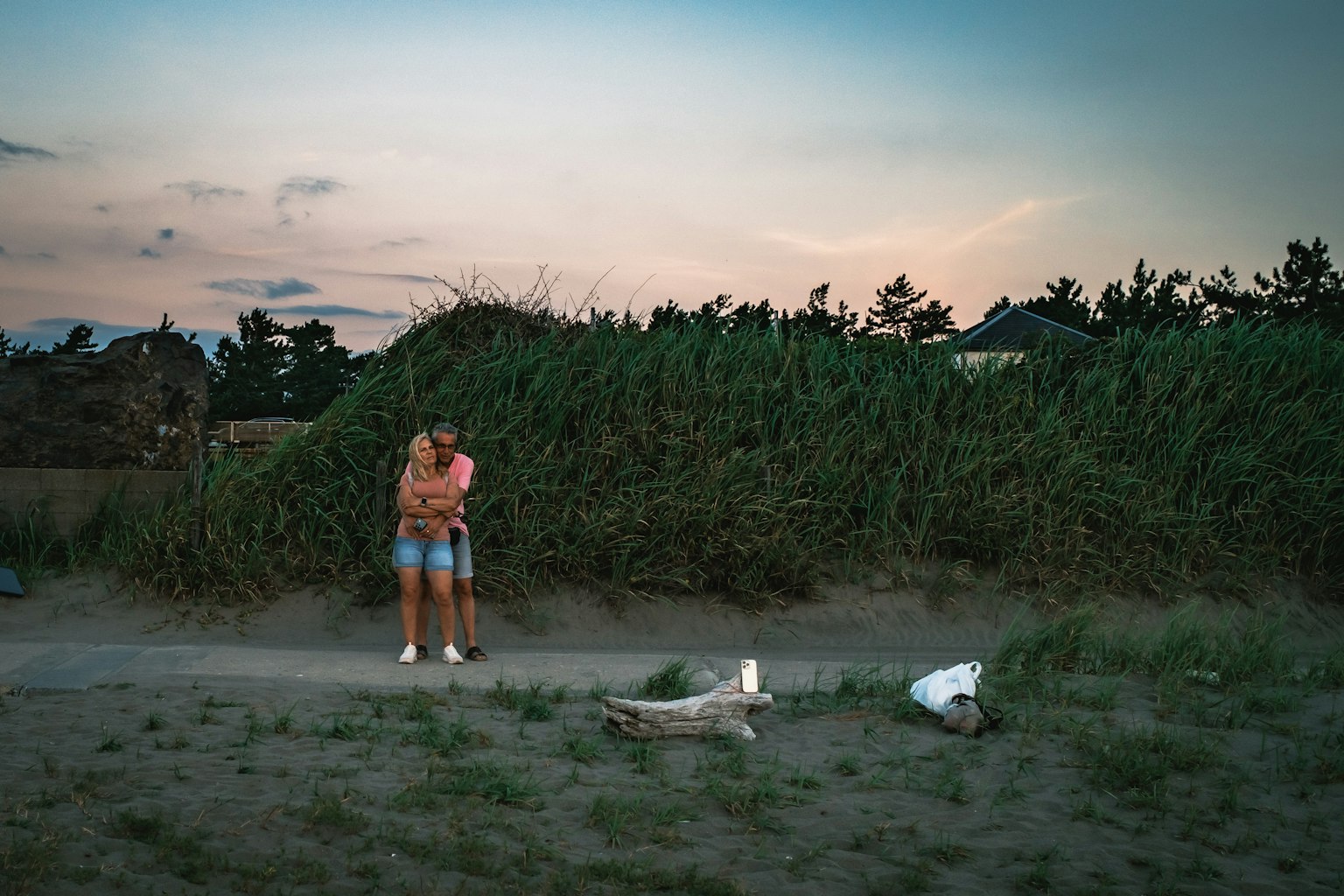 Paar steht am Strand während der Dämmerung umgeben von Natur